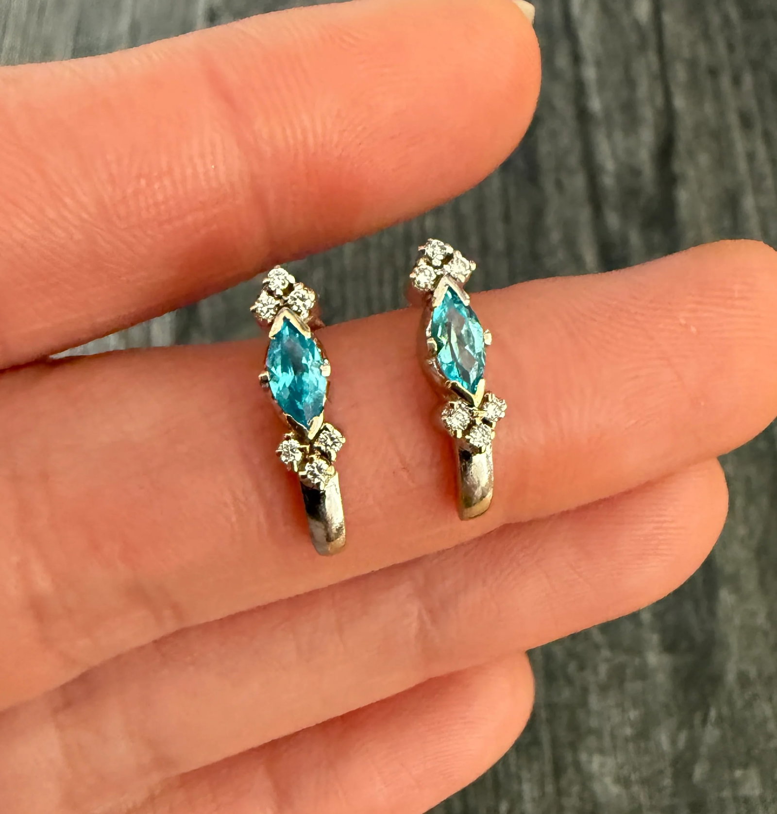 Diamond and Blue Stone Huggie Earrings in 14K Gold: Metal: 14K White Gold Weight: 2.3 gramsDiamonds: Approximately 0.18 caratsBlue Stone: Approximately 0.70 carats (possibly blue zircon)Measurements: 0.65 inches long Markings: NoneCondition: In good co