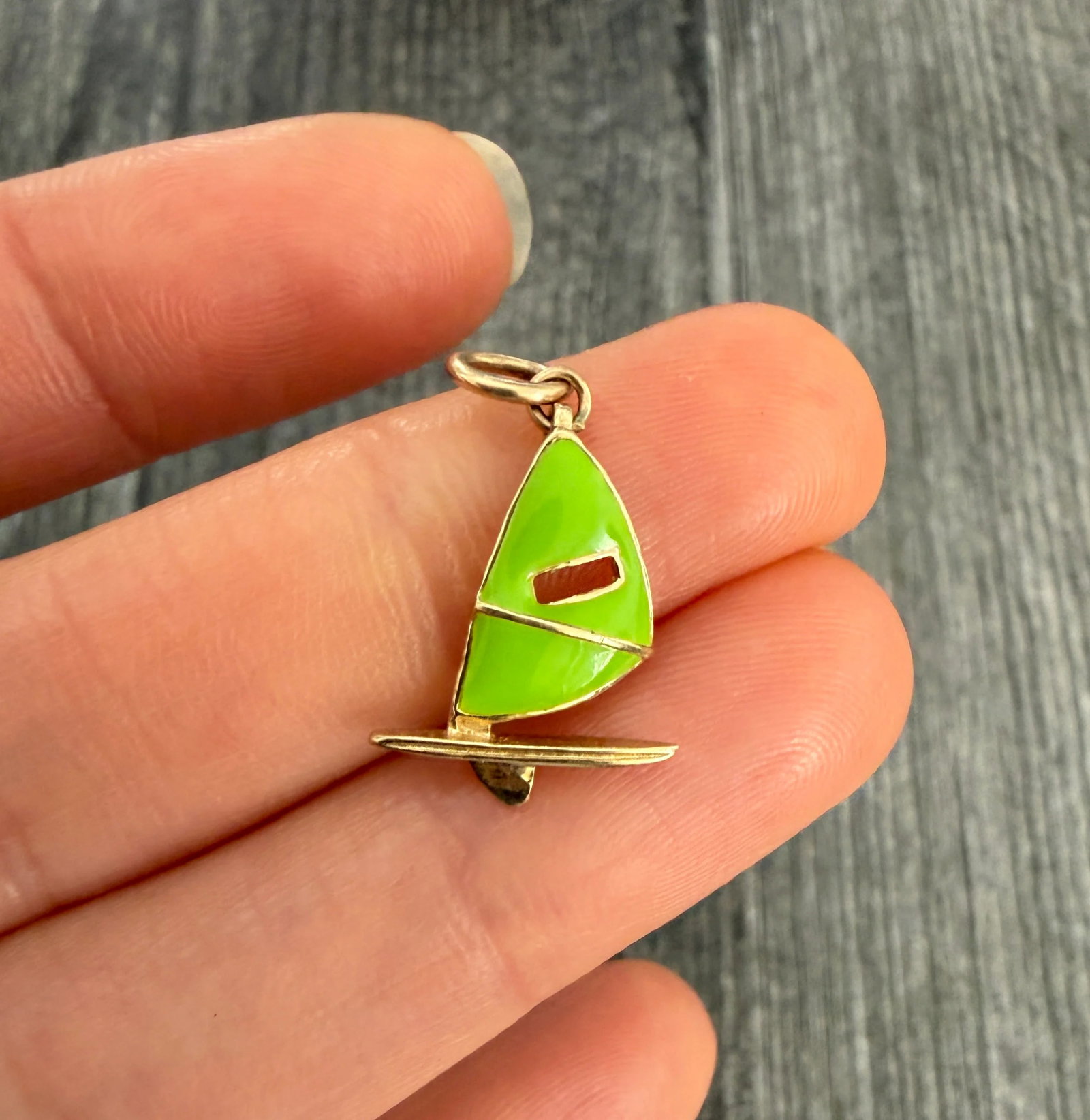 Lime Green Enamel Windsurfer Charm in 14K Gold: Metal: 14K Yellow Gold (Acid Tested)Weight: 1.2 gramsMeasurements: 0.75 inches long by 0.55 inches wideMarkings: NoneCondition: In very good condition with some minor surface wear consistent with age.