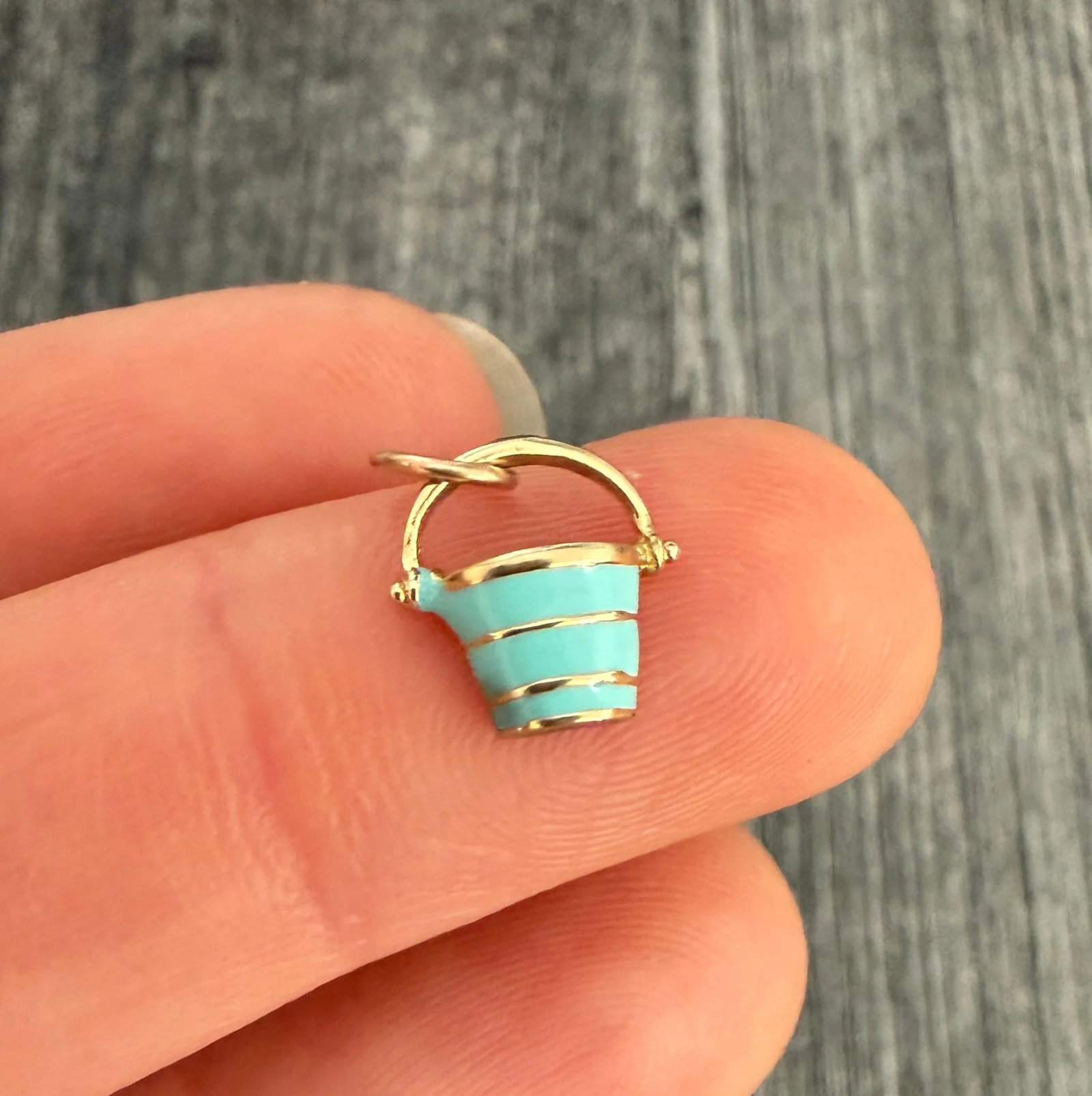 Light Blue Enamel and 14K Gold Pail or Bucket Charm: Metal: 14K Yellow Gold (Acid Tested)Weight: 0.8 gramsMeasurements: 0.35 inches long by 0.35 inches wideMarkings: NoneCondition: In very good condition with some minor surface wear consistent with age.