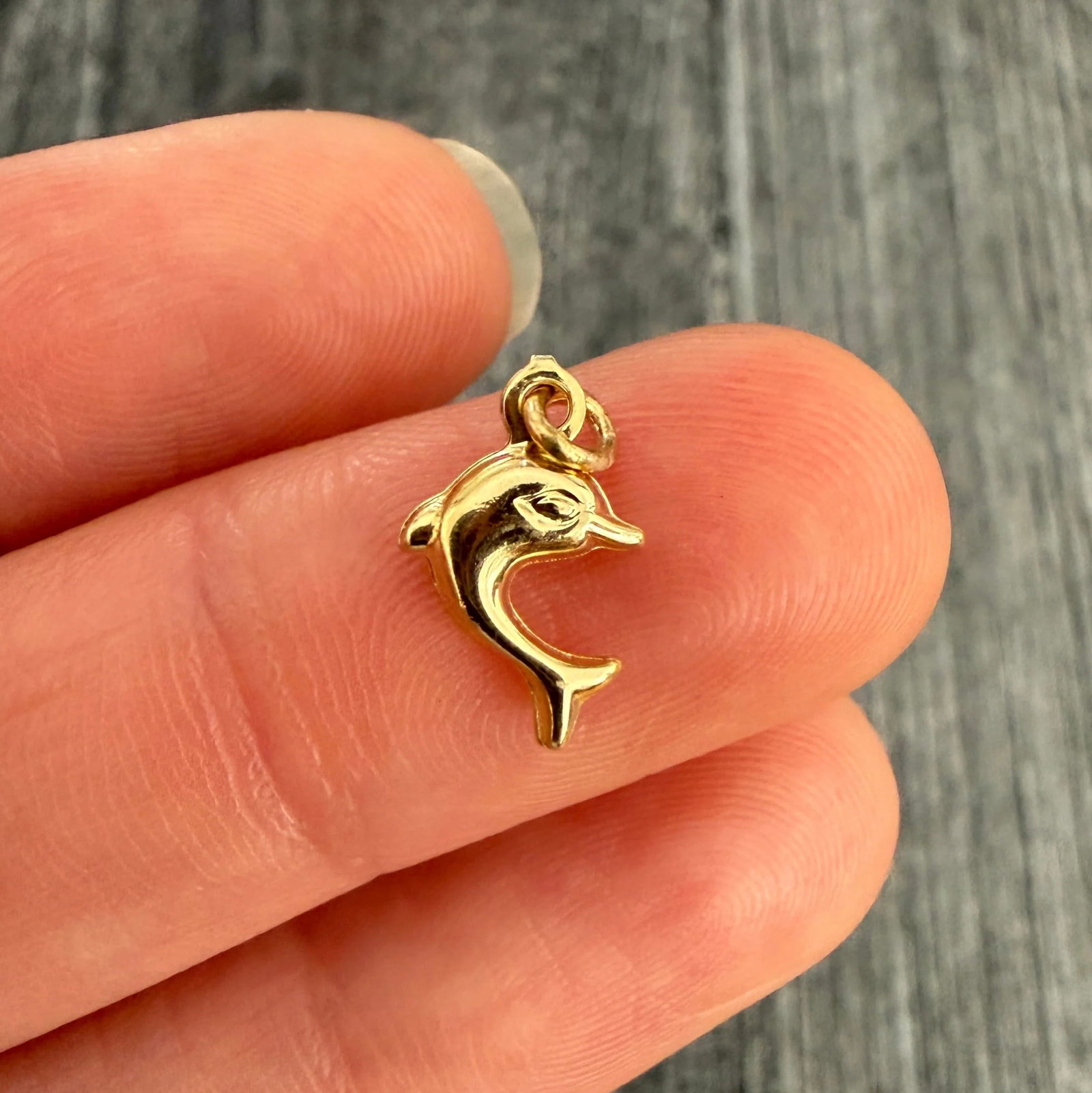 Puffy 18K Gold Dolphin Charm: Metal: 18K Yellow Gold (acid tested)Weight: 0.5 gramsMeasurements: 0.35" longMarkings: NoneCondition: In very good condition with some minor surface wear consistent with age. Follow us on Instagram @a