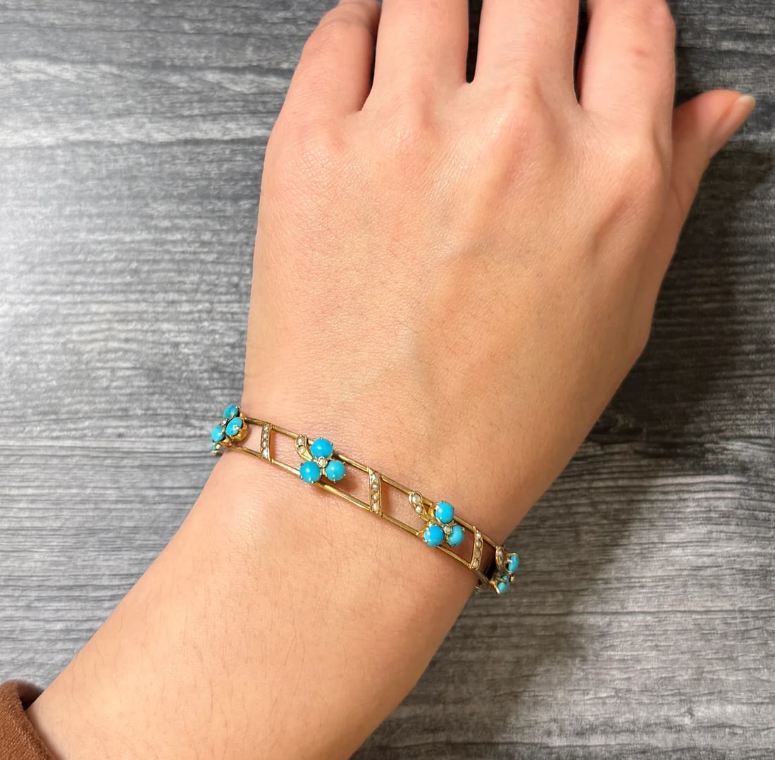 Antique Turquoise and Pearl Clover Bangle Bracelet: Metal: 14K Yellow Gold (acid tested)Weight: 13 gramsInner circumference: 6.5 inches aroundInner diameter: 1.85 inches long by 2.2 inches wide Width: 8.3 mm wide Markings: NoneCondition: In good antiqu