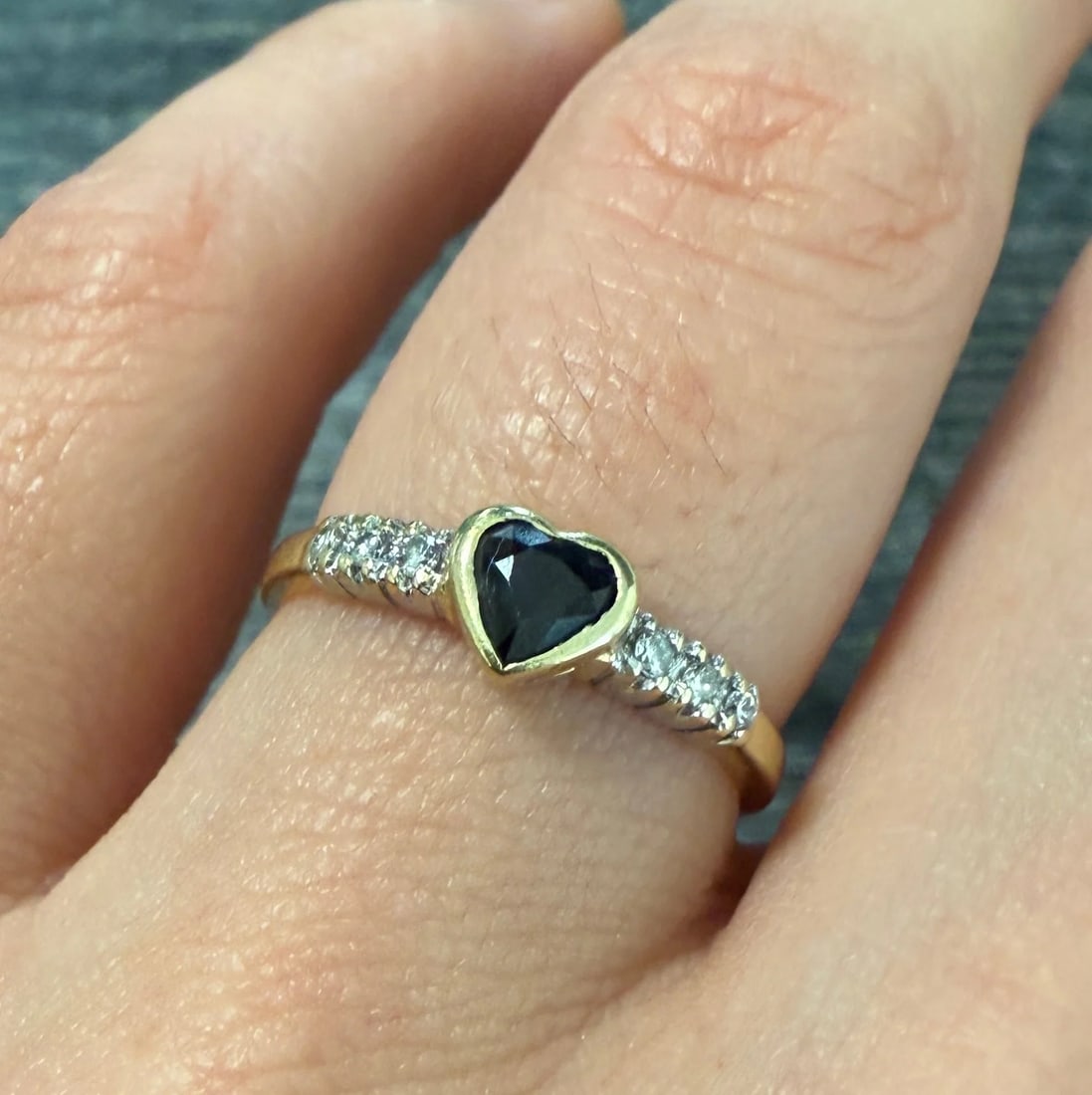 Sapphire Heart and Diamond Band in 14K Gold: Metal: 14K Yellow & White GoldWeight: 1.9 gramsSapphire: Approximately 0.20 caratsDiamonds: Approximately 0.03 caratsRing Size: 6.25 (resizable)Width: 5.1 mm wide Markings: "14K"Condition: In very goo