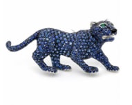 18K White Gold Sapphire & Emerald Panther Brooch: Artfully crafted 18K white gold panther motif brooch accented with fine blue sapphires and rich green emeralds.