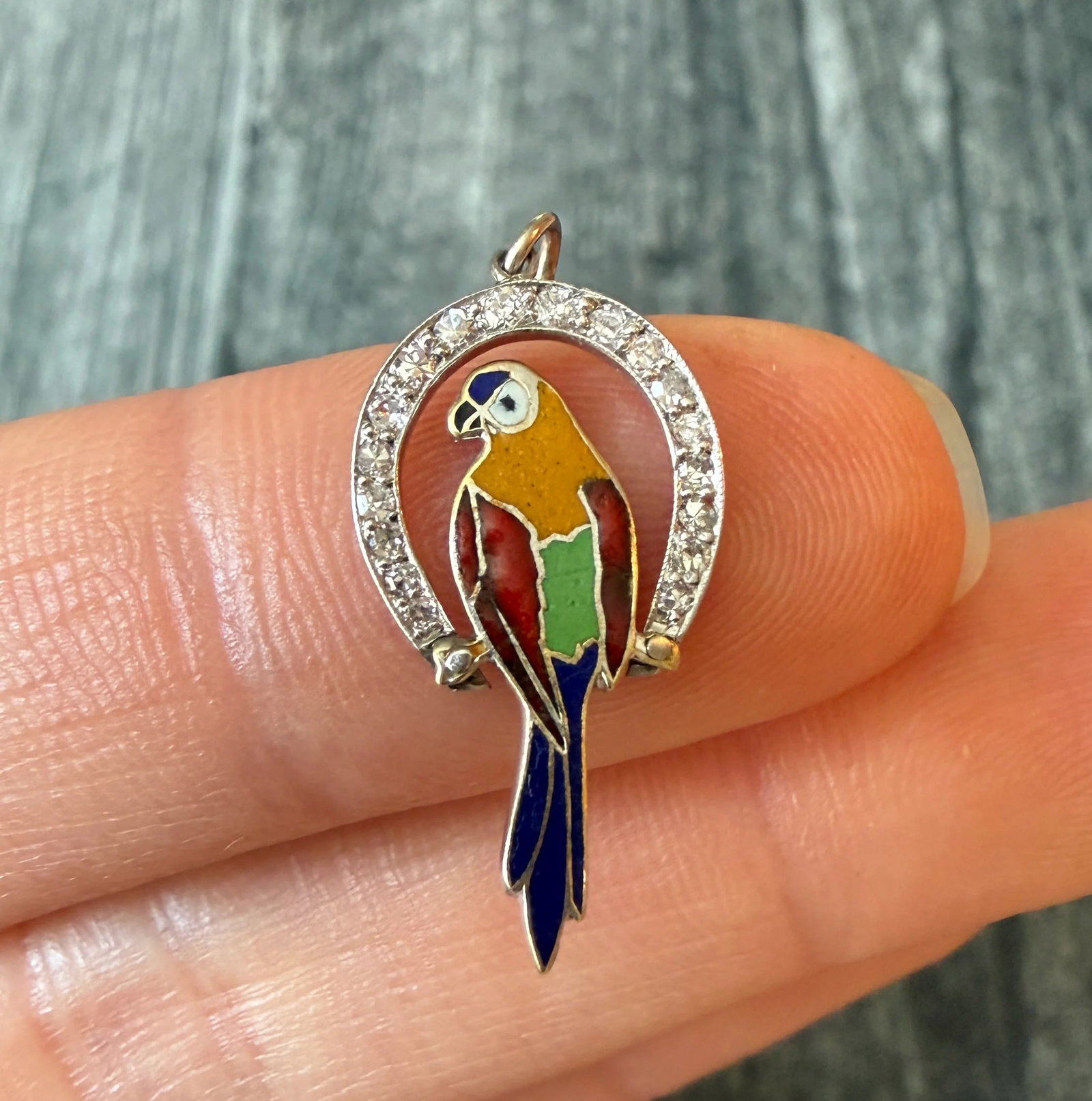 Art Deco Diamond and Enamel Parrot Charm in Platinum (J): Metal: Platinum (acid tested)Weight: 1.2 gramsDiamonds: Approximately 0.09 caratsMeasurements: 0.8 inches long by 0.5 inches wideCondition: In good condition with some minor surface wear Follow us on 