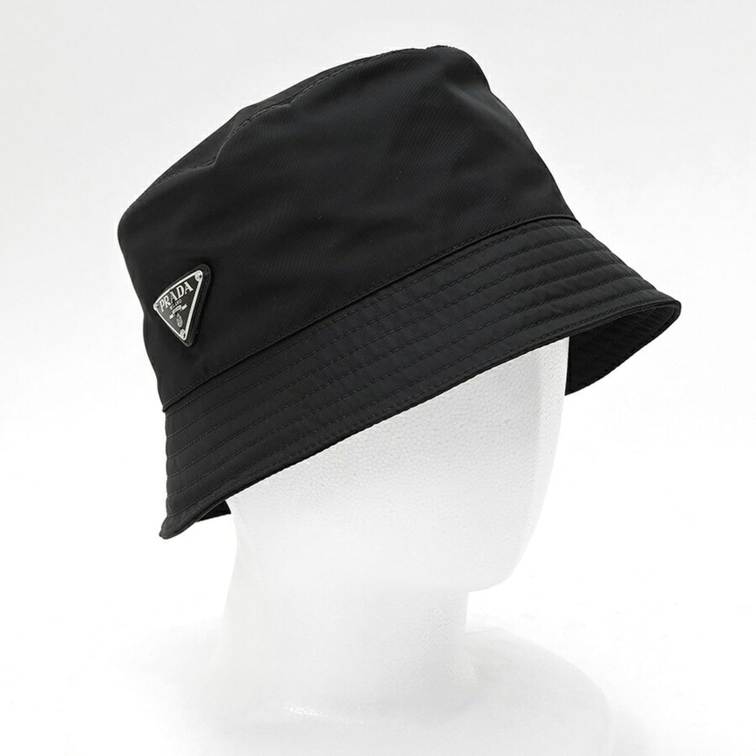 Prada PRADA Re-Nylon Triangle Bucket Hat 1HC137 Nylon Black # L: --- Catalog ---Category: DesignType: Bucket hatColor: BlackGender: Men,WomenMaterial: Nylon Category: GeneralBrand: PradaCountry of Origin: ItalyCategory: MeasurementsCircumference: 59cm / 23.22''--- 