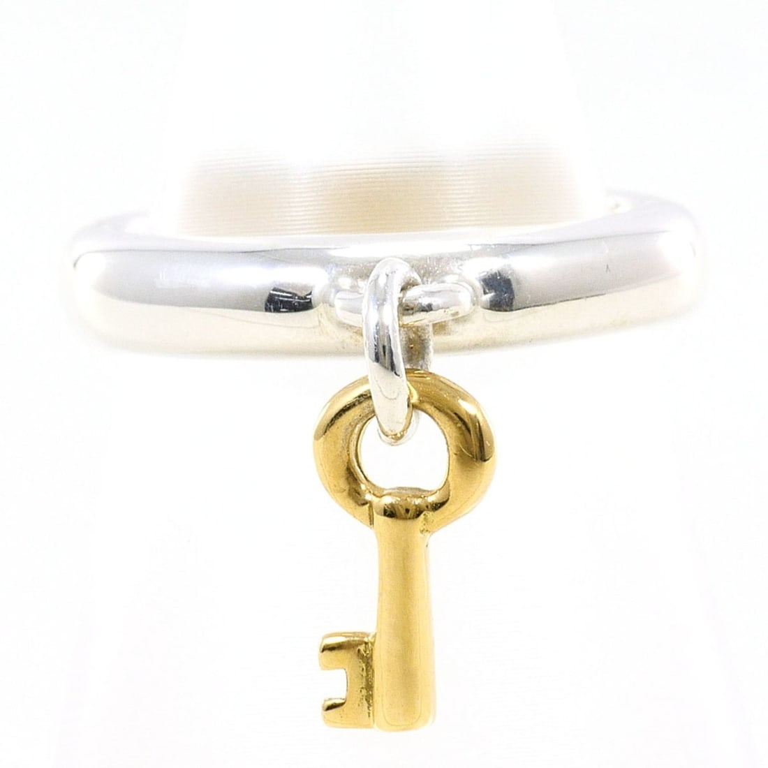 Tiffany & Co. Key 18K Yellow Gold Silver Ring (Total Weight: 4.7g) Jewelry: --- Catalog ---Category: SizeWidth: 14mm / 0.55''Weight: 4.7g / 0.16oz.JP Size: 8US Size: 4.5Category: DesignType: Band ringGender: WomenMaterial: Silver 925, Yellow gold (18K)Category: GeneralBrand: 