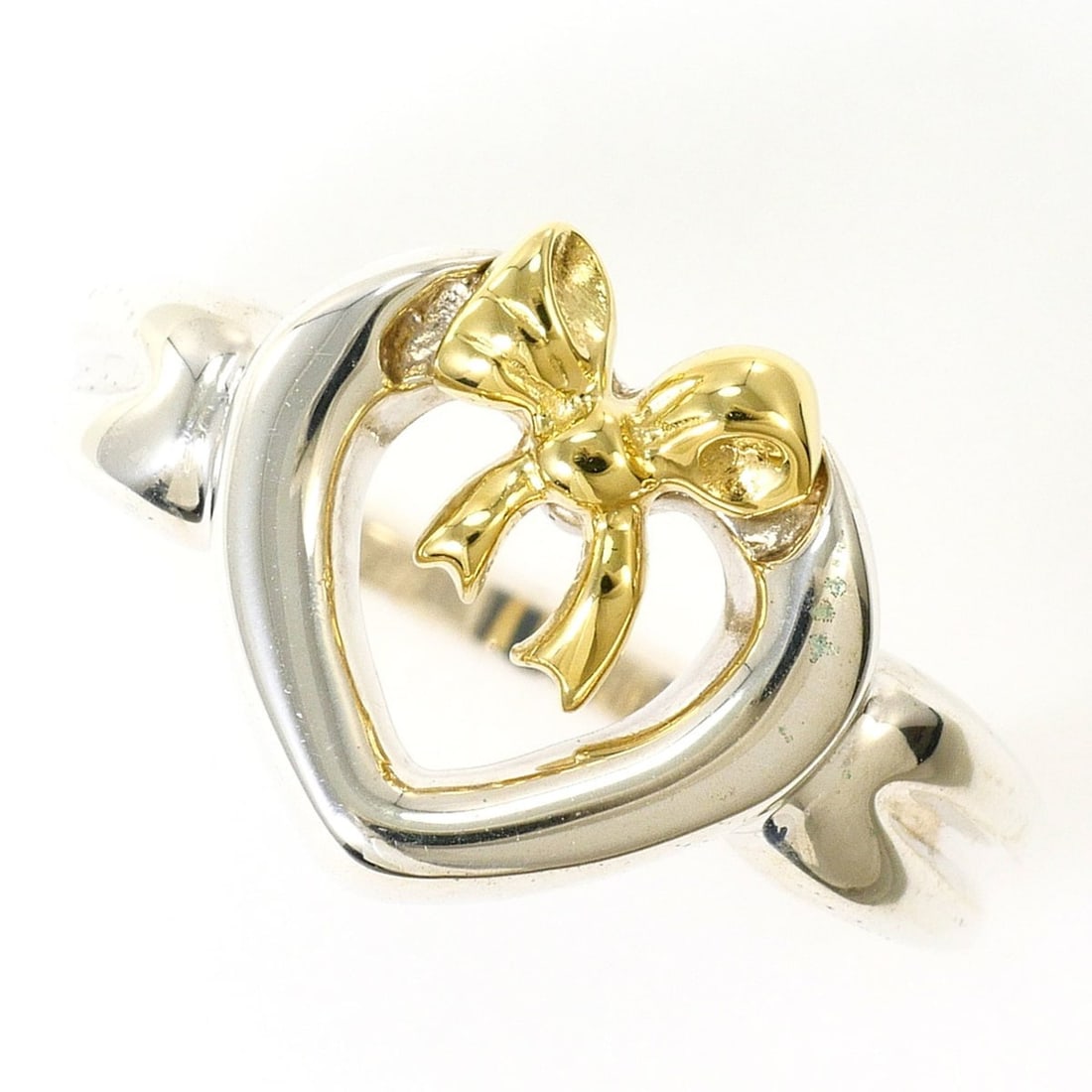 Tiffany & Co. Heart Ribbon 18K Yellow Gold Silver Ring (Total Weight: 3.9g) Jewelry: --- Catalog ---Category: SizeWidth: 11mm / 0.43''Weight: 3.9g / 0.13oz.JP Size: 7.5US Size: 4Category: DesignType: Band ringGender: WomenMaterial: Silver 925, Yellow gold (18K)Category: GeneralLine: H