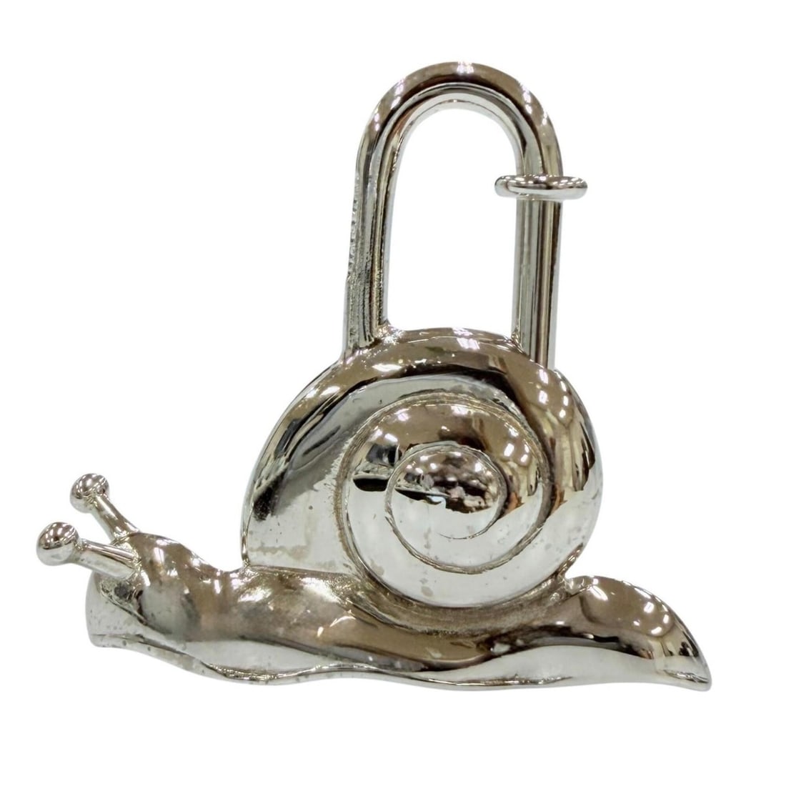HERMES Vintage La Route Padlock Snail Metal Charm, 1995 Limited Edition, Silver, Women's Accessory: --- Catalog ---Category: SizeSize (HxWxD): 33.00mm x 35.00mm / 1.30'' x 1.38''Category: DesignType: Handbag charmColor: SilverGender: WomenMaterial: MetalCategory: GeneralBrand: Hermes--- Item List --