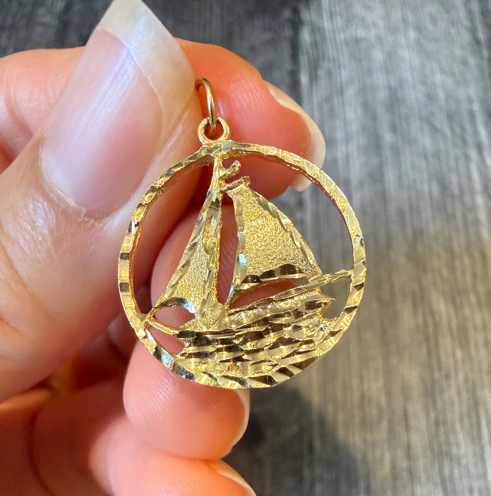 Vintage Sailboat Charm in 14K Gold: Metal: 14K Yellow GoldWeight: 1.9 gramsMeasurements: 0.8 inch diameter Markings: "14K”Condition: In very good condition with some minor surface wear.