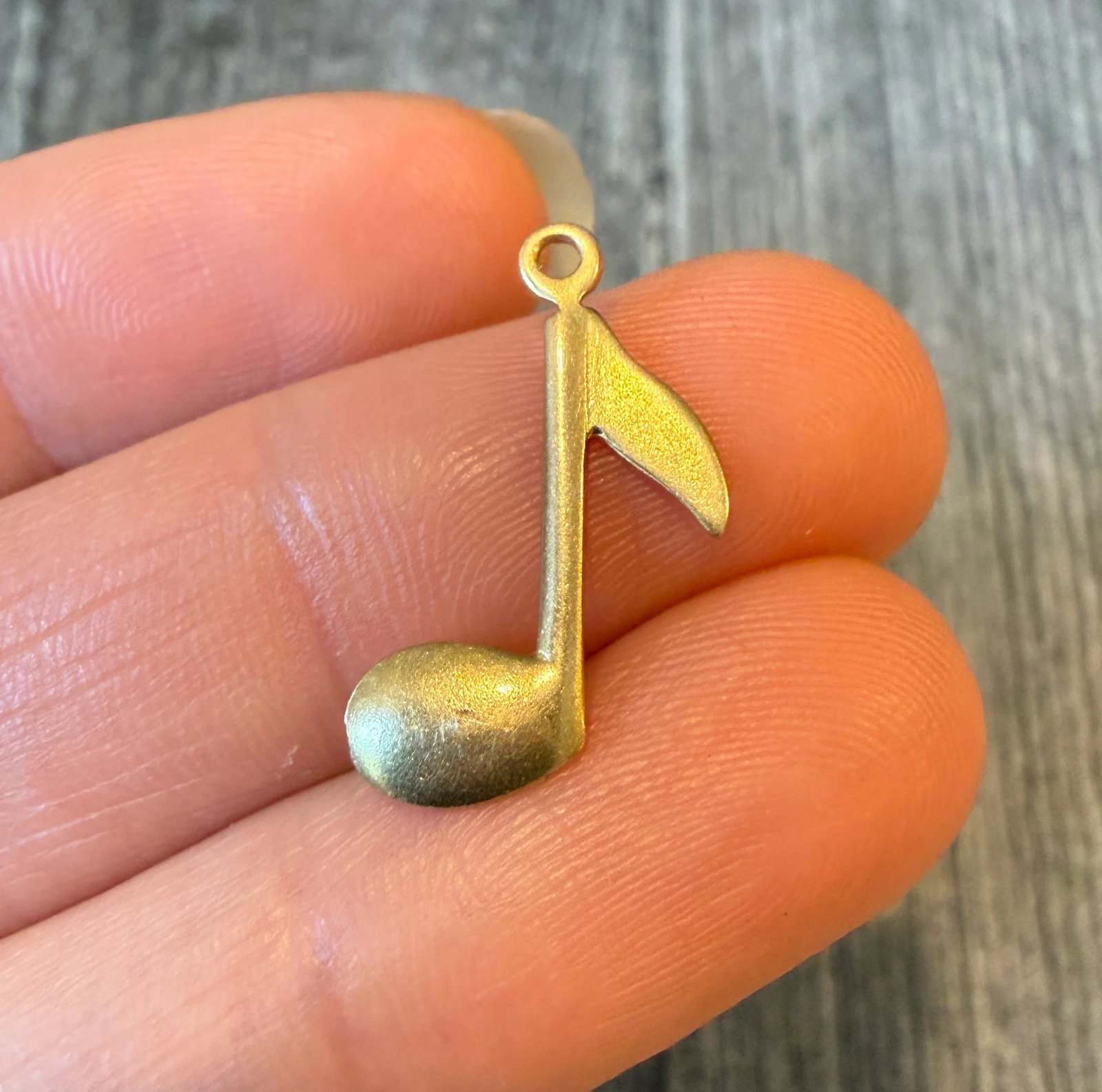 Musical Note Charm in 14K Gold: Metal: 14K Yellow Gold Weight: 0.6 gramsMeasurements: 0.75 inches long by 0.55 inches wideMarkings: "14K"Condition: In very good condition with some minor surface wear. A bale can be added if