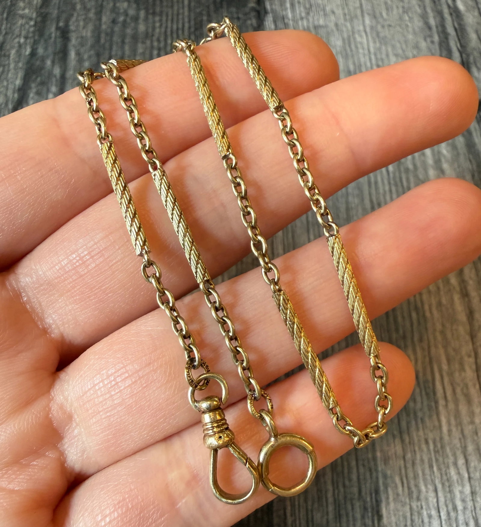 Art Deco 14K Gold Swirly Tubular Bar Link Watch Chain, 13.75?? Long: Metal: 14K Yellow Gold Weight: 10.6 gramsMeasurements: 13.75 inches long by 2.1 mm wideMarkings: "Kreisler & Co NY 14K"Condition: In very good condition with some minor surface wear.