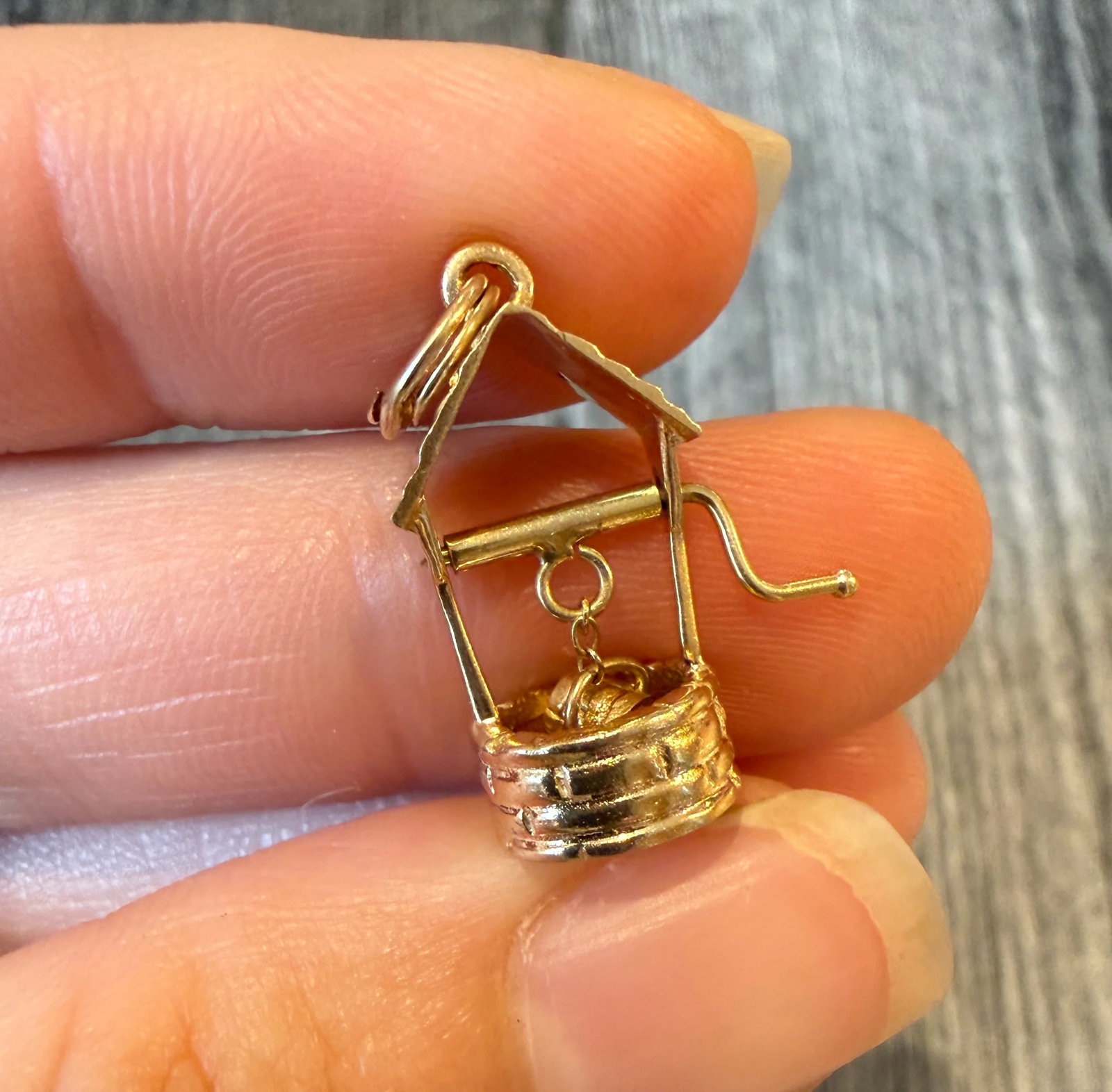 Movable Wishing Well Charm in 14K Gold: Metal: 14K Yellow Gold (Acid Tested)Weight: 2.6 gramsMeasurements: 0.8 inches long by 0.7 inches wideCondition: In good condition with some minor surface wear.