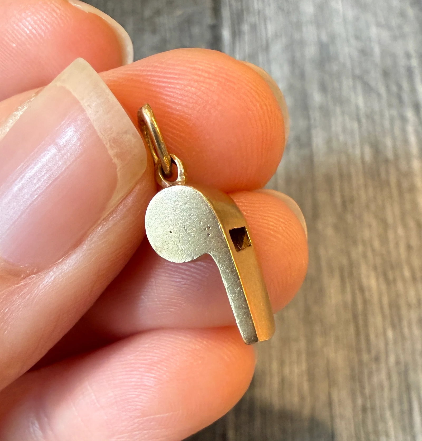 Narrower Whistle Charm in 14K Gold: Metal: 14K Yellow Gold Weight: 1.6 gramsMeasurements: 0.55 inches long by 0.2 inches wideMarkings: “14K"Condition: In good condition with some minor surface wear.
