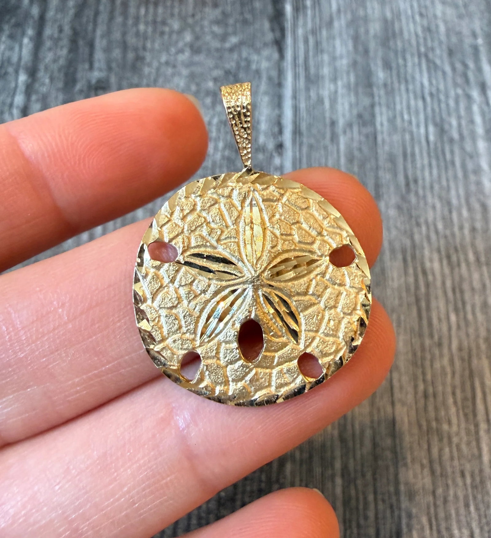 Large Sand Dollar Charm in 14K Gold: Metal: 14K Yellow Gold Weight: 4.3 gramsMeasurements: 1 inch diameterCondition: In very good condition with some minor surface wear.