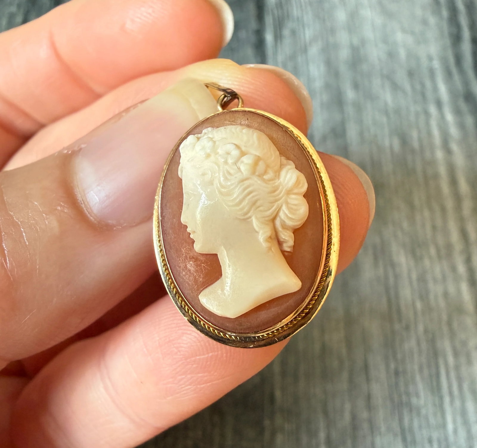 Carved Shell Cameo of a Woman's Profile in 14K Gold: Metal: 14K Yellow Gold Weight: 2.8 gramsMeasurements: 0.9 inches long by 0.7 inches wideMarkings: "K14”Condition: In good condition with some minor surface wear