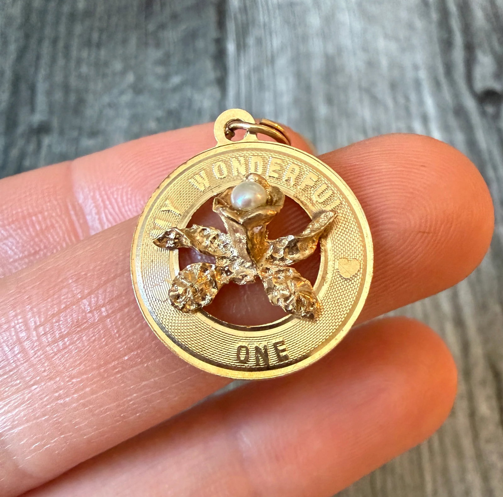 "My Wonderful One" Orchid Charm in 14K Gold: Metal: 14K Yellow Gold Weight: 1.9 gramsMeasurements: 0.75 inch diameterMarkings: "14K"Condition: In good condition with some minor surface wear