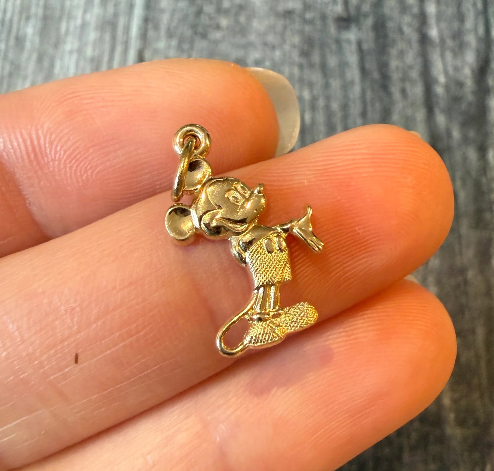 Mickey Mouse Charm in 14K Gold: Metal: 14K Yellow Gold Weight: 1.3 gramsMeasurements: 0.7 inches long by 0.5 inches wideMarkings: "DISNEY 14KT"Condition: In very good condition with some minor surface wear