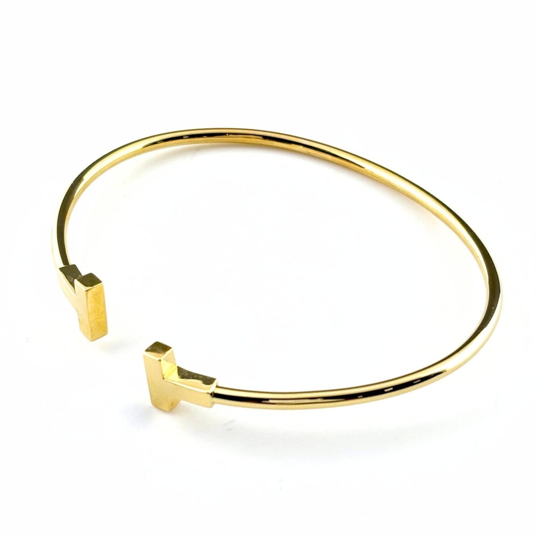 Tiffany & Co. T Wire YG Yellow Gold Bangle Bracelet 750 for Women: --- Catalog ---Category: SizeLength: 17.5cm / 6.88''Category: DesignType: BangleGender: WomenMaterial: Yellow gold (18K)Category: GeneralBrand: Tiffany--- Item List ---Section: ConditionRanking: Rank 