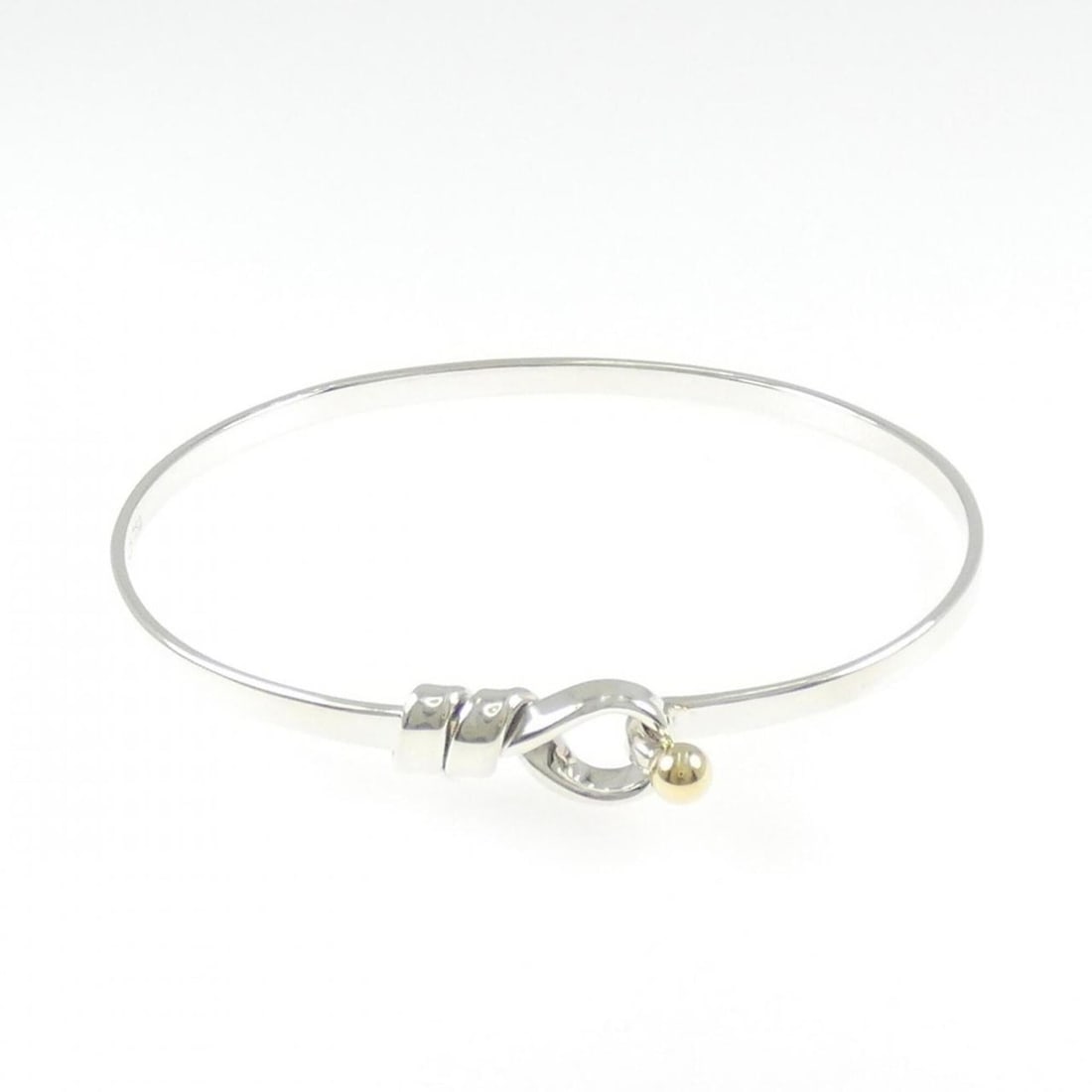 Tiffany Hook & Eye Bangle: --- Catalog ---Category: SizeLength: 17cm / 6.69''Category: DesignType: BangleGender: WomenMaterial: Silver 925, Yellow gold (18K)Category: GeneralBrand: Tiffany--- Item List ---Section: ConditionRank