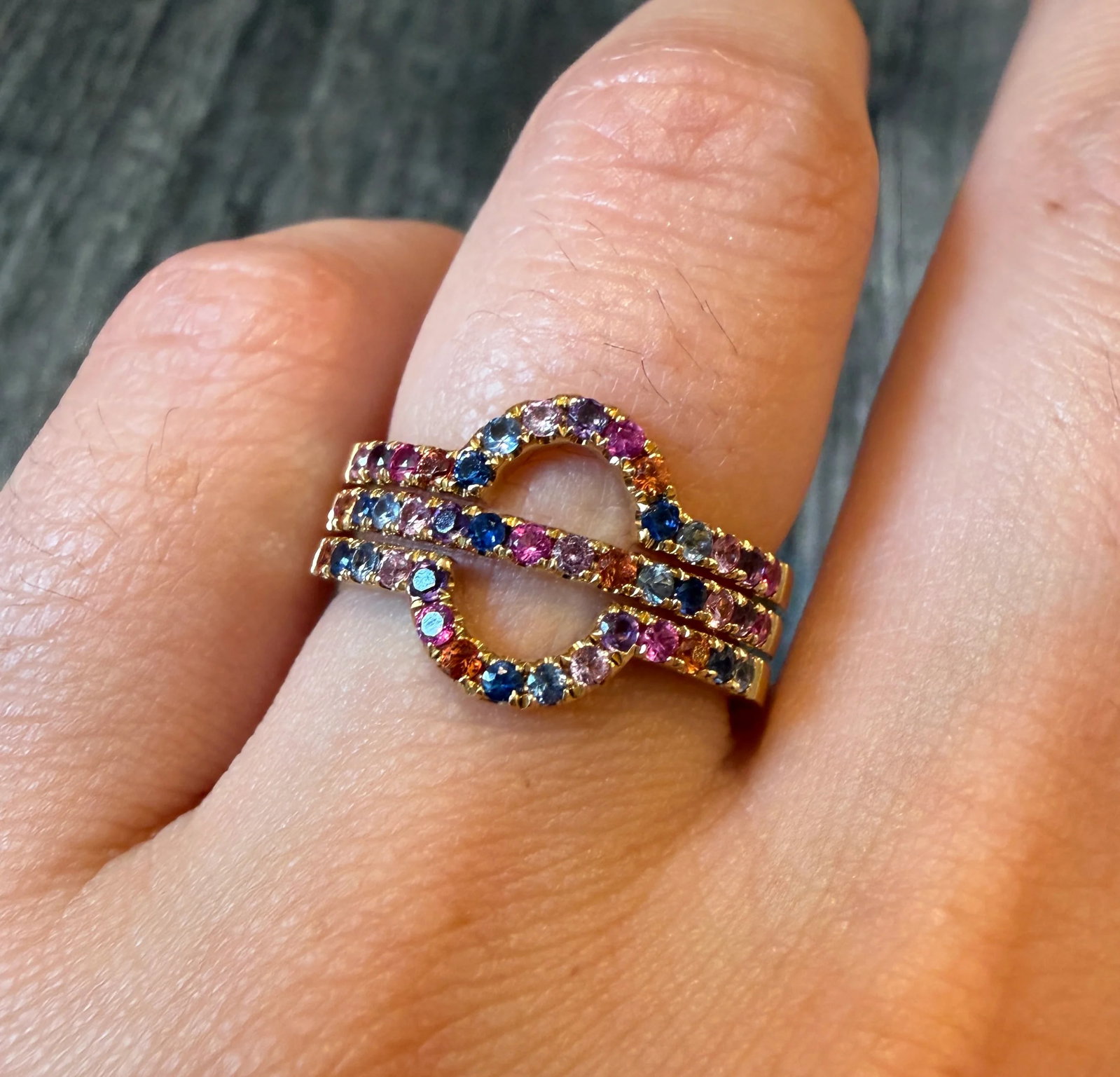 Rainbow Sapphire and 18K Gold Orbit Stacked Ring (I): Metal: 18K Yellow Gold Weight: 7.7 gramsSapphires: Approximately 0.90 caratsRing Size: 6.75 (resizable)Width: 11.8 mm wide Markings: "DW 750" Condition: In very good condition with some minor surface 