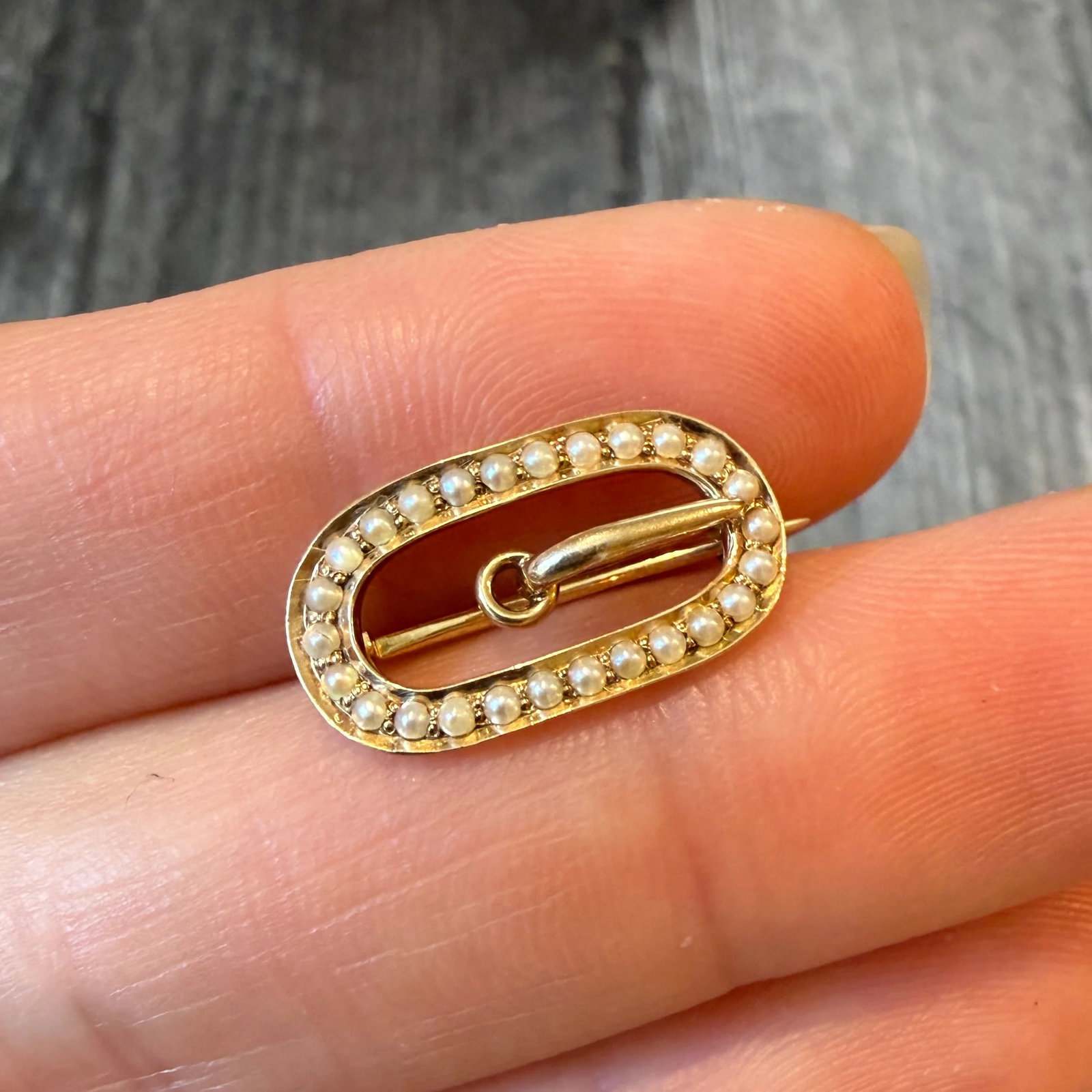 Antique Split Pearl and 14K Gold Buckle Pin: Metal: 14K Yellow Gold Weight: 1.6 gramsMeasurements: 0.45 inches long by 0.75 inches wideMarkings: "14K"Condition: In very good condition with some minor surface wear.Follow us on Instagram @alphaome