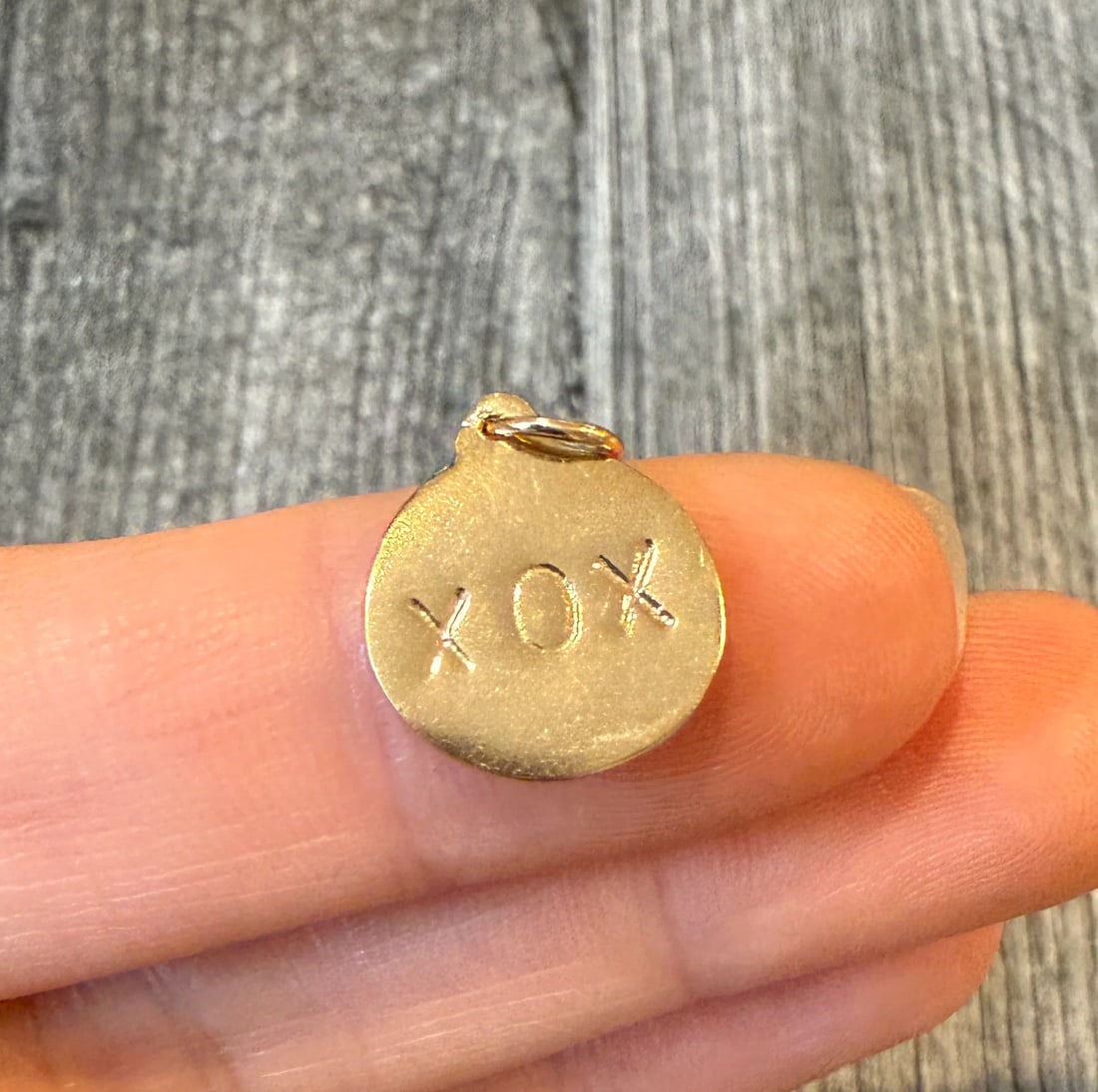 "XOX" Disc Charm in 14K Gold: Metal: 14K Yellow Gold Weight: 1.6 gramsMeasurements: 0.5 inch diameter Markings: "14K"Condition: In good condition with some minor surface wear.Follow us on Instagram @alphaomegajewelry for the lates