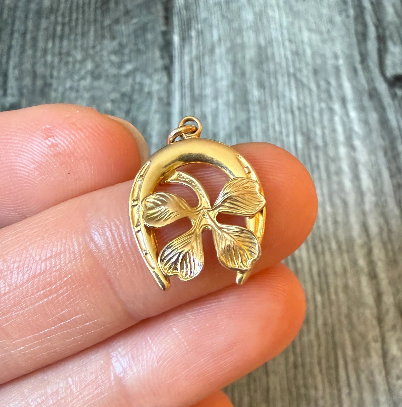 Lucky Horseshoe and Four Leaf Clover Charm in 14K Gold: Metal: 14K Yellow Gold Weight: 1.8 gramsMeasurements: 0.7 inches long by 0.65 inches wideMarkings: "14K"Condition: In good condition with some minor surface wear Follow us on Instagram @alphaomegajewe