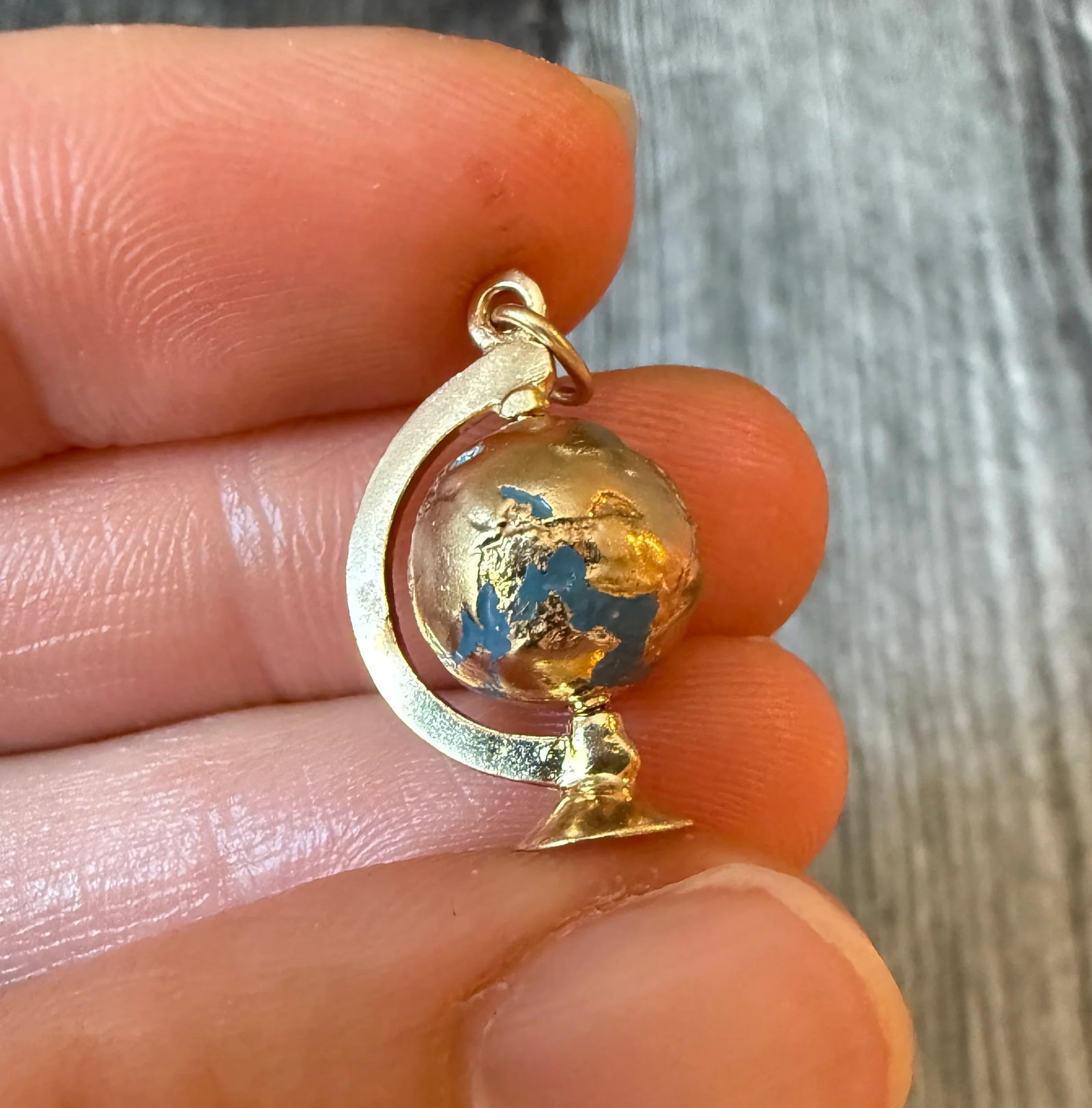 Spinning Enamel Globe Charm in 14K Gold: Metal: 14K Yellow Gold Weight: 3.7 gramsMeasurements: 0.75 inches long by 0.65 inches wideCondition: In good condition with some minor surface wear Follow us on Instagram @alphaomegajewelry for the la