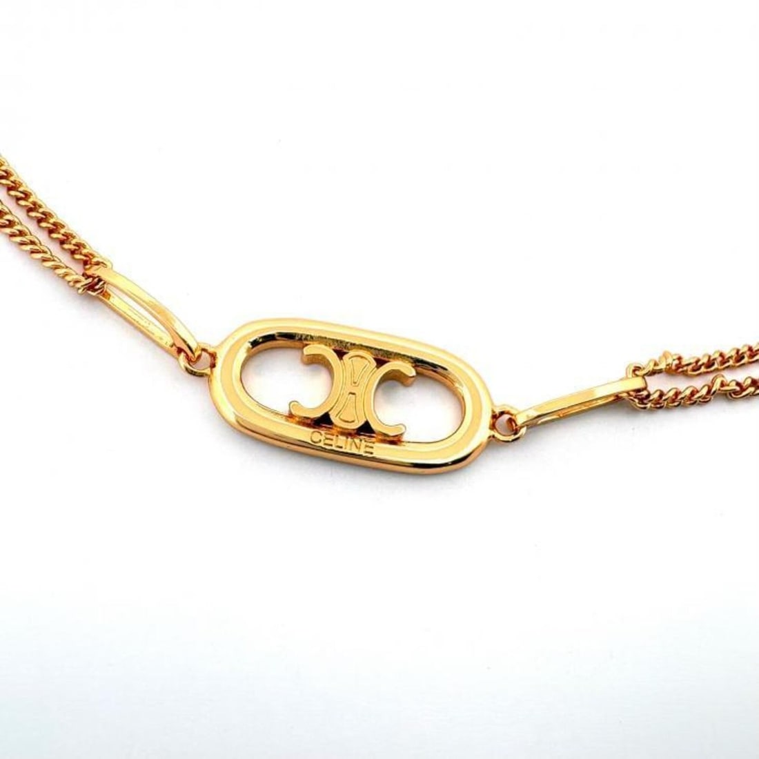Celine Triomphe Double Chain Necklace, Gold Color, 46S896BRA.35OR: --- Catalog ---Category: SizePendant Size: 11mm x 50mm / 0.43'' x 1.96''Neck Circumference: 39.5 cm - 45 cm / 15.55'' - 17.71''Category: DesignColor: GoldGender: WomenMaterial: Gold platingNecklace Ty