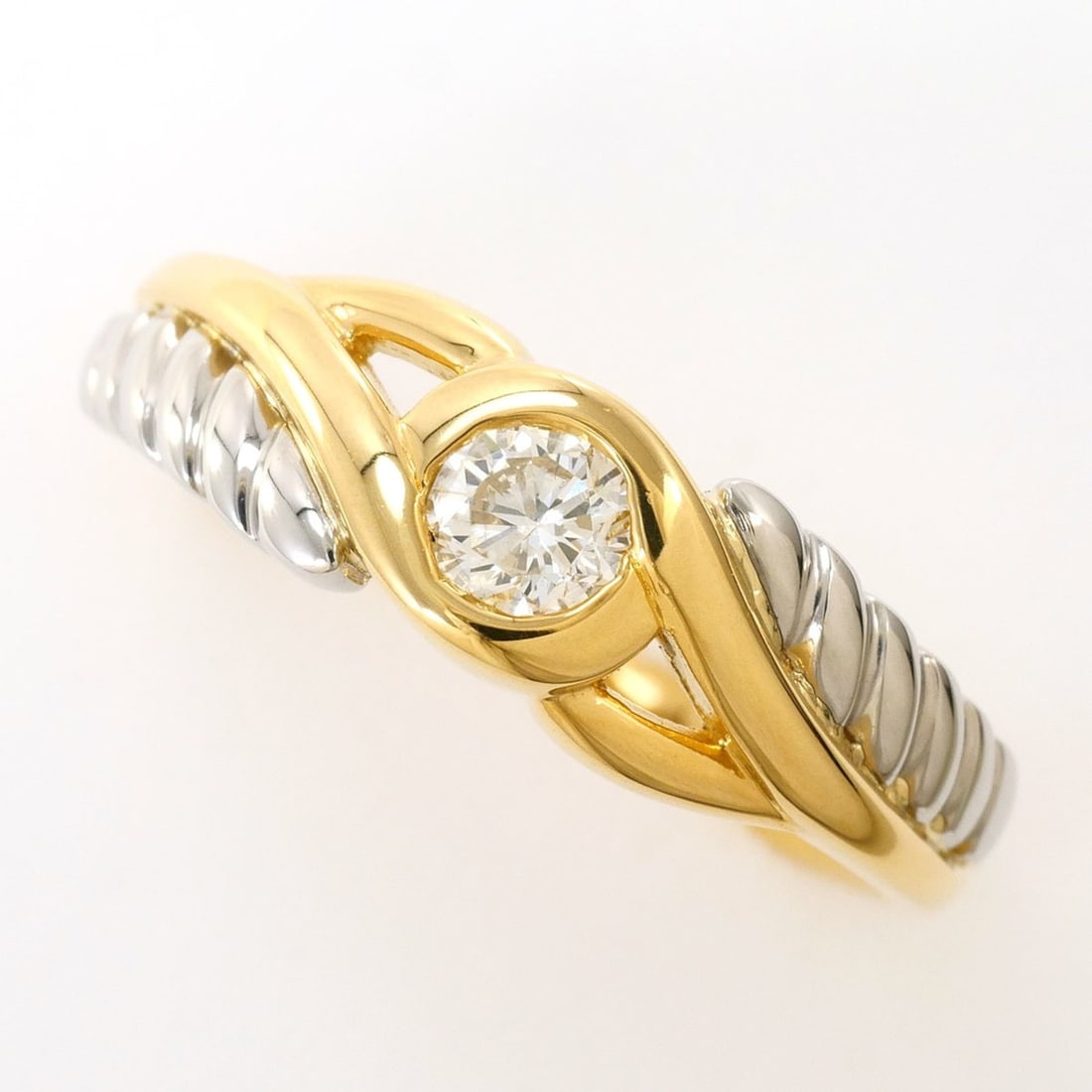 Platinum (PT) and yellow gold (YG) ring with a 0.20ct diamond, total weight 3.4g.: --- Catalog ---Category: SizeWidth: 6mm / 0.24''Weight: 3.4g / 0.11oz.JP Size: 8.5US Size: 4.5Category: DesignType: Band ringColor: Platinum, Yellow goldMetal: Gold, PlatinumStone: DiamondGender: Wome