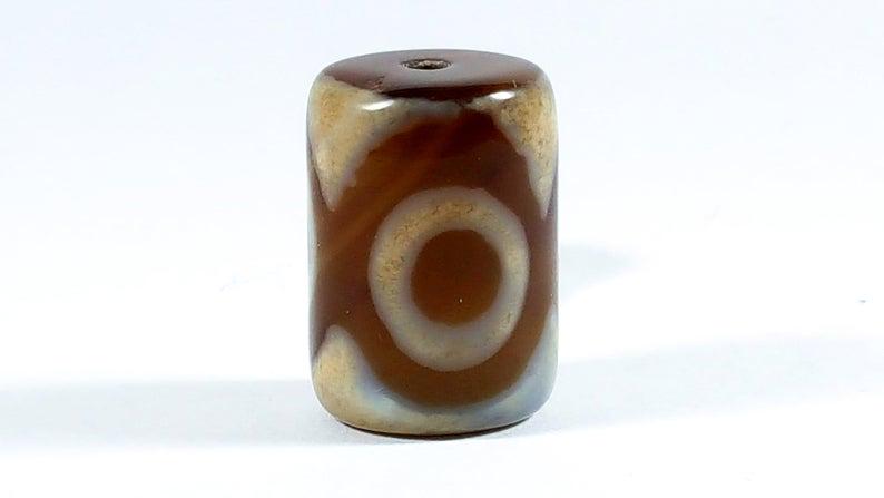 Three Eye Barrel Dzi: Dzi beads are believed to have strong powers to bring Luck, Wealth, Good Health, and Success. They also Expel Evil and Act as a Protector. The Three Eye Motif is believed to bring happiness, success, 