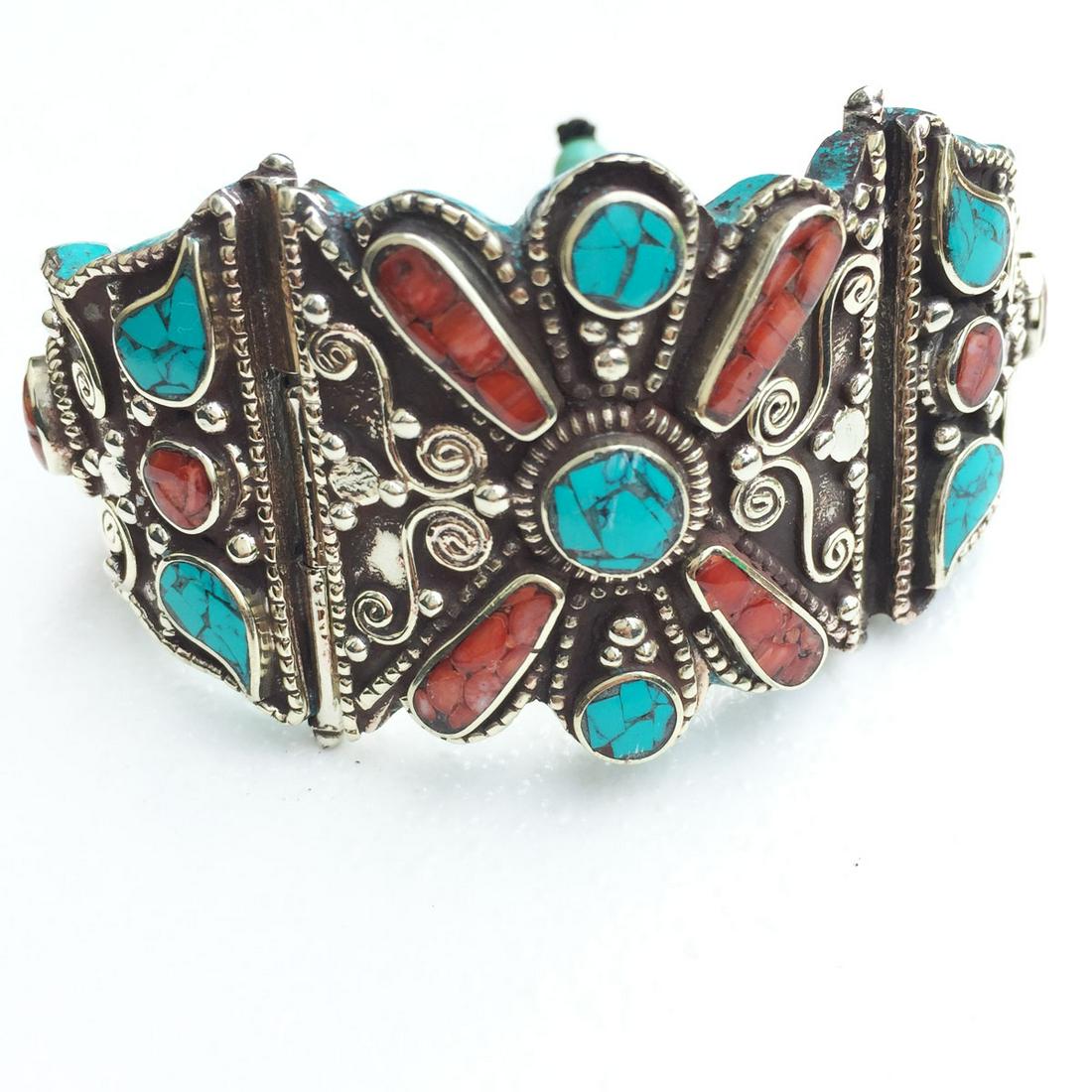 Tibetan Silver Turquoise & Coral Hand-Carved Ethnic: Tibetan Silver Turquoise Hand-Carved BangleWeight: 80 Gram ApproxGemstones: Turquoise & CoralBrand: HandmadeBangle Size: FreeCountry/Region of Manufacture: Nepal