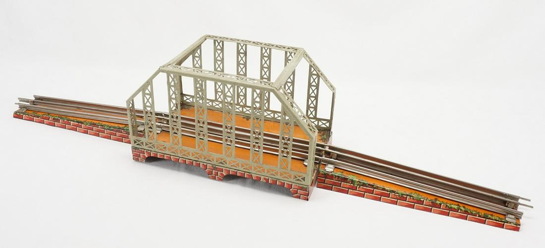 Bing Gittermast Brücke Spur 0 1. Hälfte 20.: Blech lithografiert mit Schienen und zwei Auffahrtsrampen altersgemäßer Zustand L. 80 cm Bing bridge scale O 1st half of the 20th century lithographed tin with rails and two ramps 