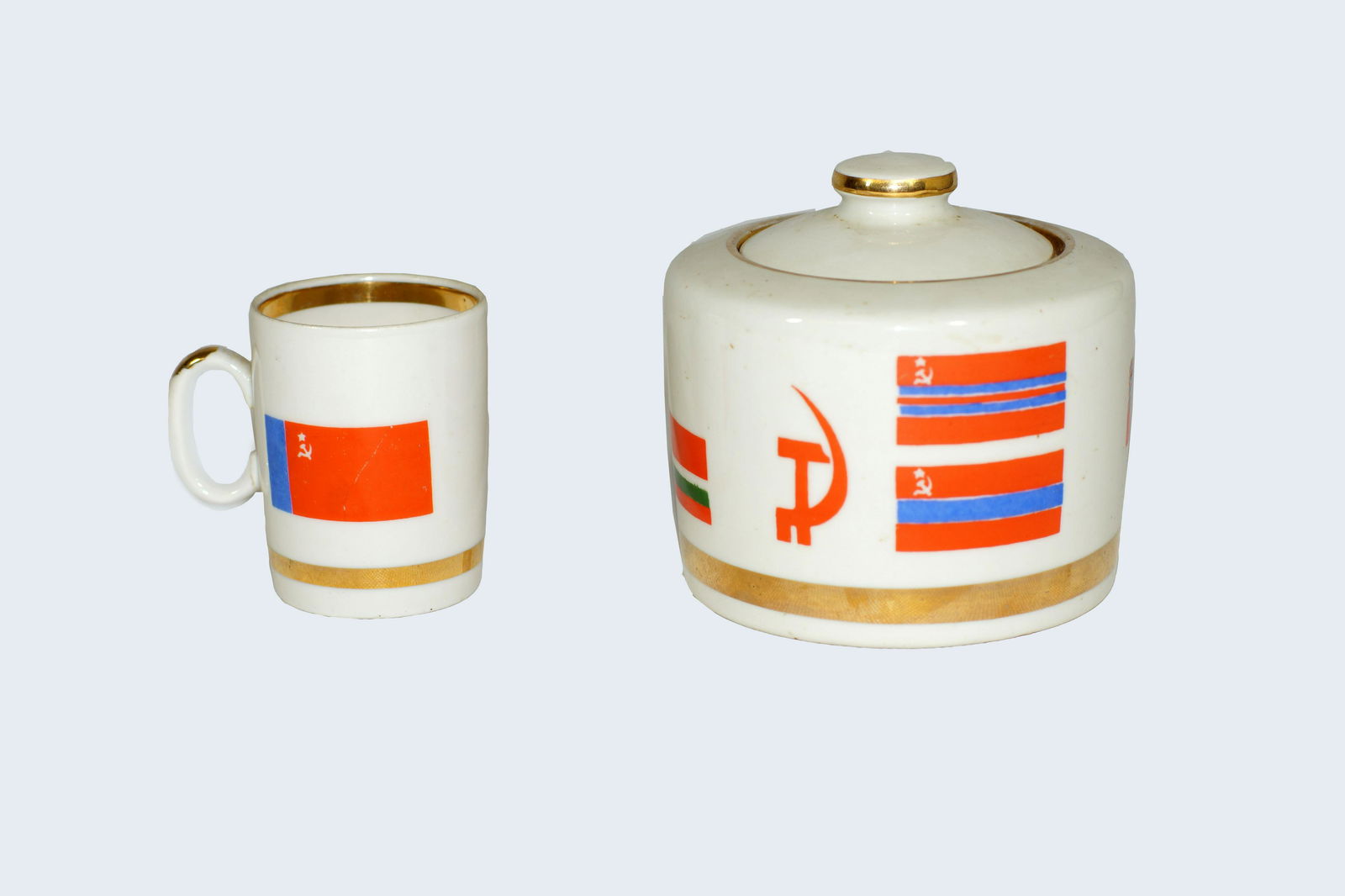 Vintage 1950 Soviet porcelain cup and sugar bowl: Vintage Russian Soviet porcelain propaganda teacup and sugar bowl featuring Soviet flags, hammer and cycle. Circa 1950. Marked VERBILKI on the bottom under glaze. Size cup h 2.75". Size sugar bowl d 4