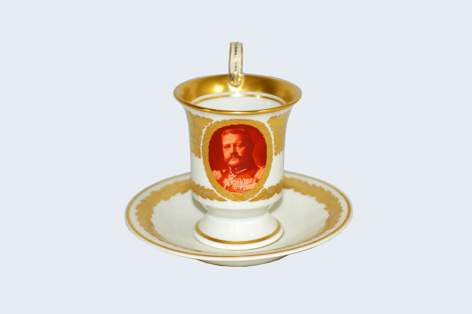 Antique KPM Porcelain Tea Cup and Saucer: Antique 19th Century German KPM Berlin Gilt Porcelain Cabinet Tea cup and saucer. WWI BISMARK depicted on the cup. Authentic mark on the bottom. Size cup h 4.75". Plate d 5.75".