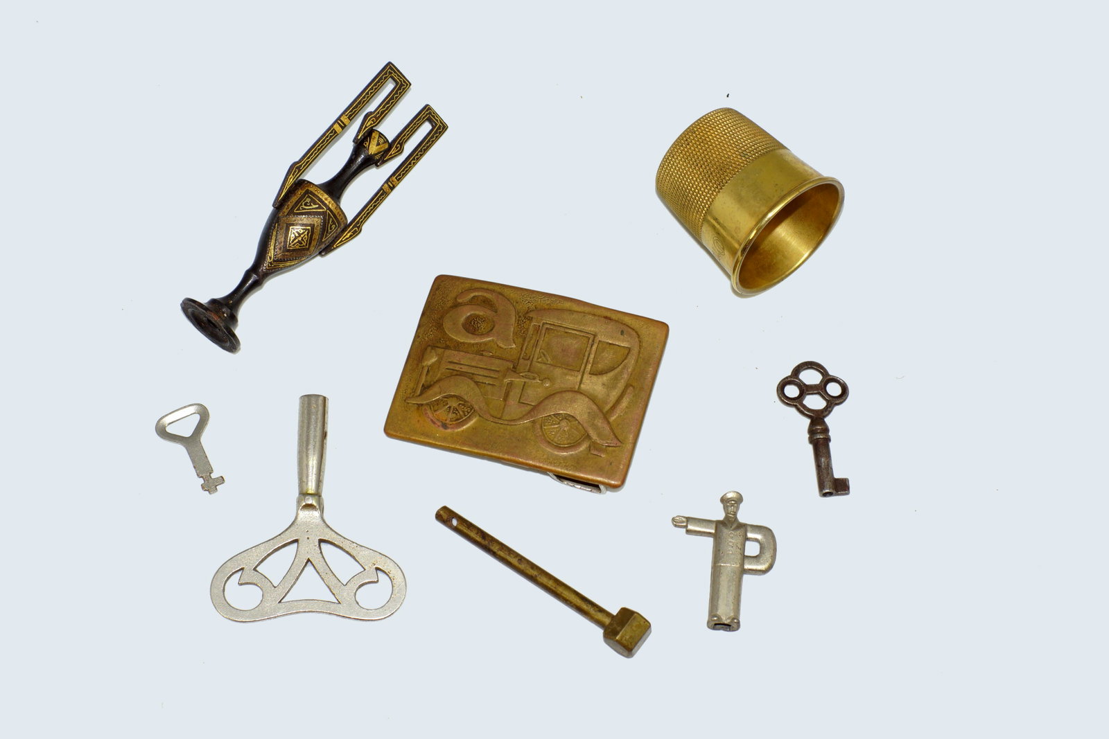 Assorted Antique Metal Objects: Assorted Antique Metal Objects. Include vintage brass belt bucket, thimble shaped vodka metal shot cup, miniature vase, 5 keys.