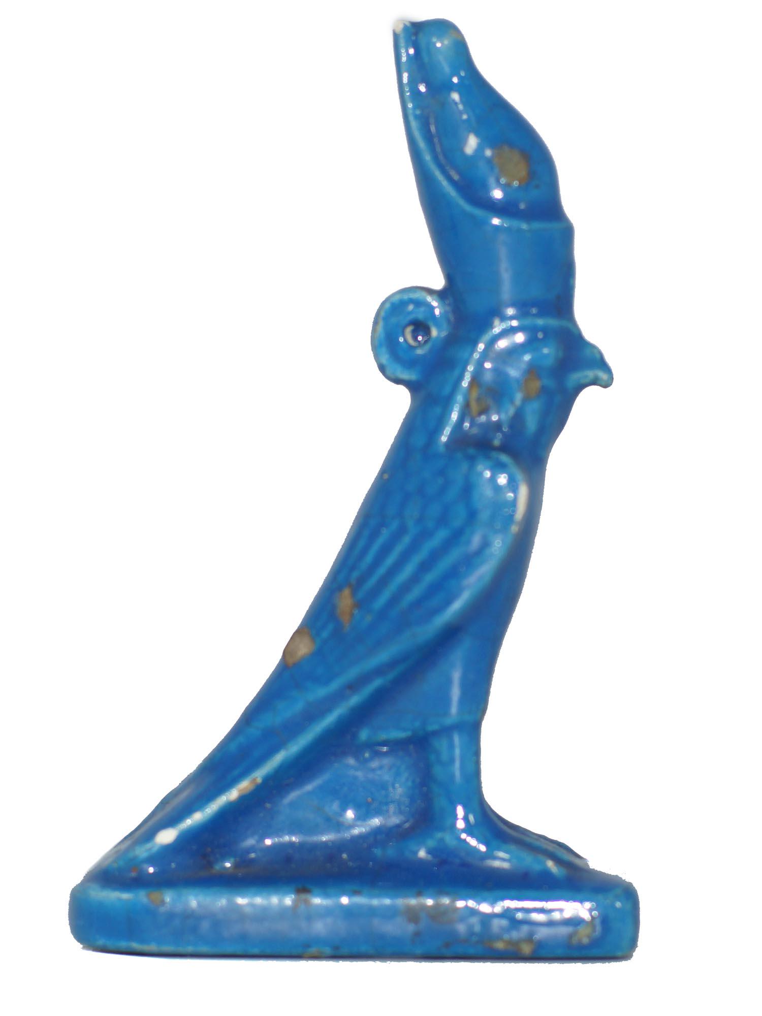 A Ancient Egyptian Blue Faience Eye of Horus Bird: This figurine of a falcon wearing the double crown of Upper and Lower Egypt represents an image of divine kingship. Painted in light-blue color, glazed, on a rectangular base. Age and origin are uncer
