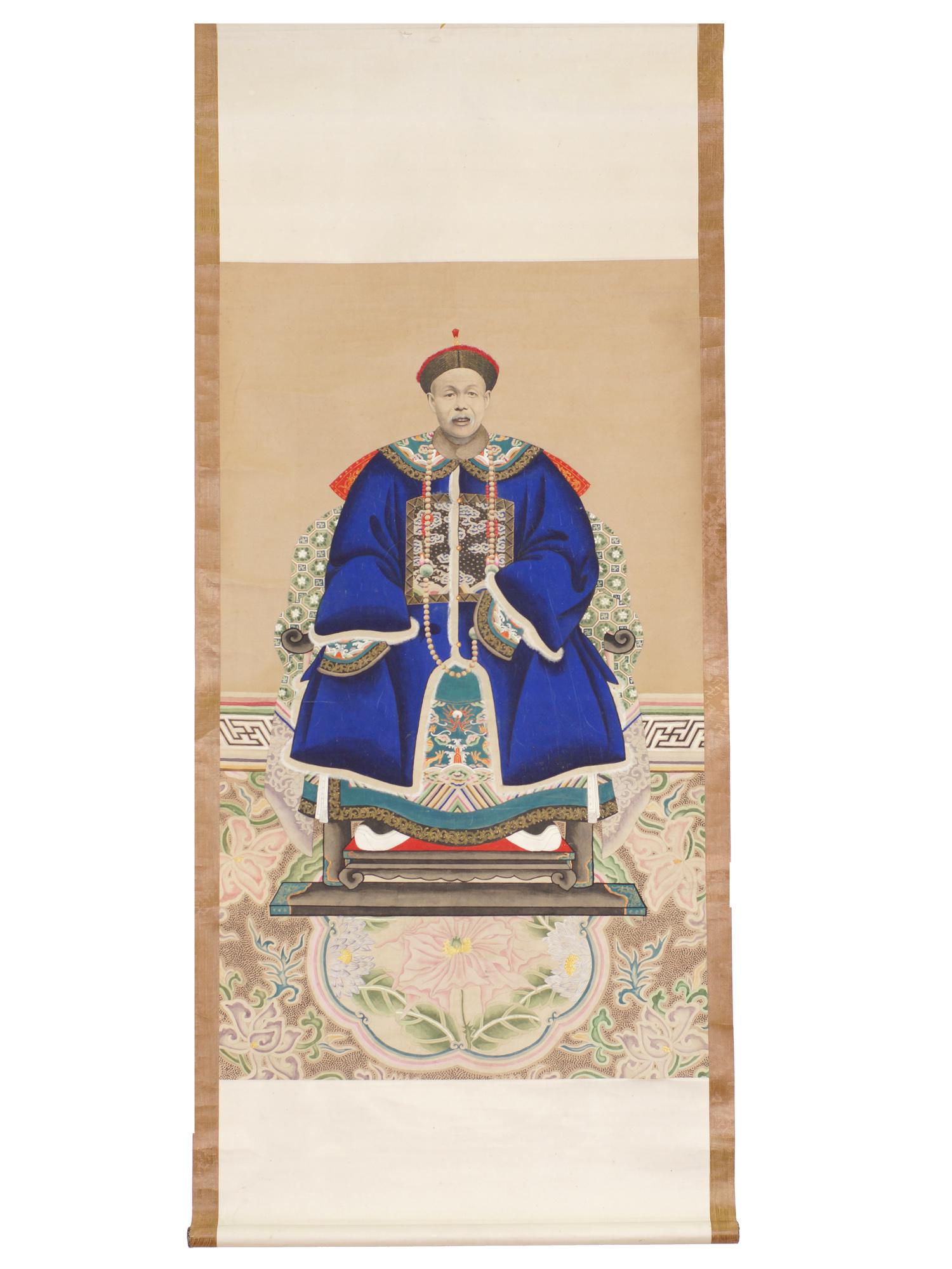 A CHINESE ANCESTOR PORTRAIT. LATE 19TH CENTURY: Ink and color on paper. The depicted official is dressed in formal clothes with fur lined hat and a luxurious blue robe with embroidery. The man sits on a silk armchair against a background of a carpe