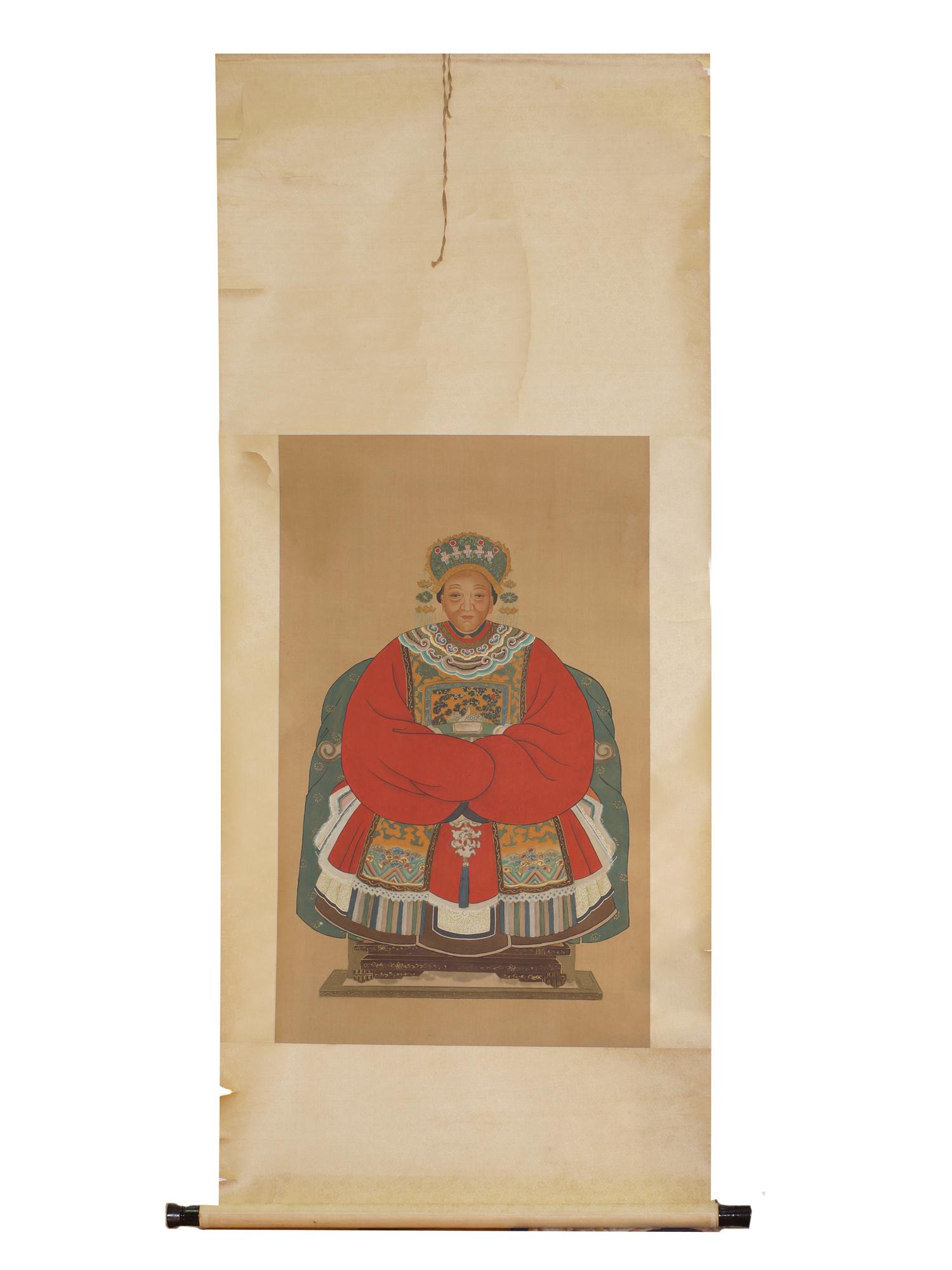 A CHINESE ANCESTOR PORTRAIT OF AN OFFICAL'S WIFE. 19TH: The elderly woman depicted with an elaborate headdress with pendants. A civil official rank badge is worn on a traditional red robe. She is sitting in a silk-draped armchair. Ink and color on paper. P
