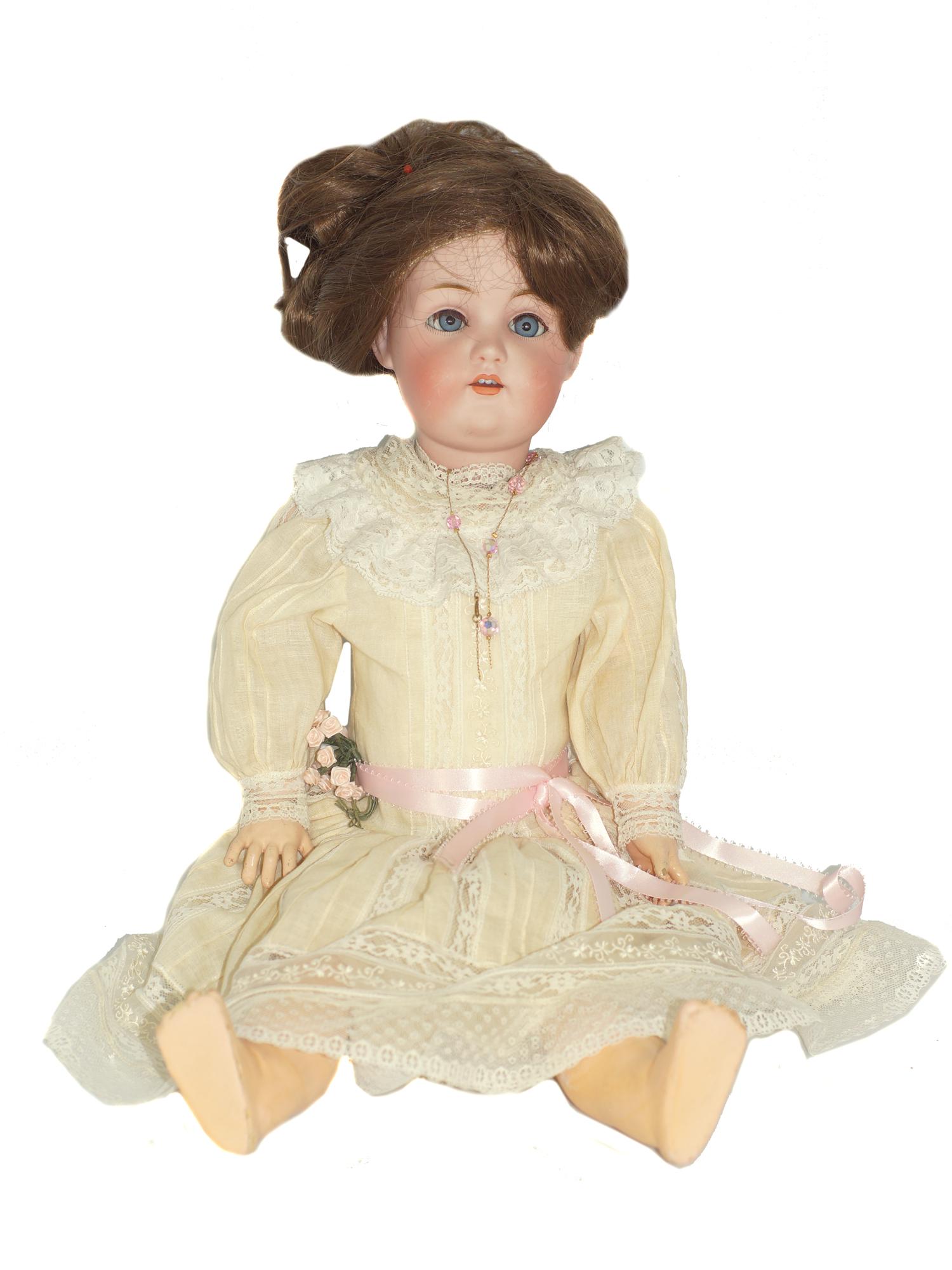 AN ANTIQUE JOHANN DANIEL KESTNER GERMAN DOLL: An antique doll with bisque head. Manufactured by J.D.K- Johann Daniel Kestner. The doll is made in Germany and the head is marked with "J 214 13". The doll has blue eyes, a wig, and is wearing an ivo