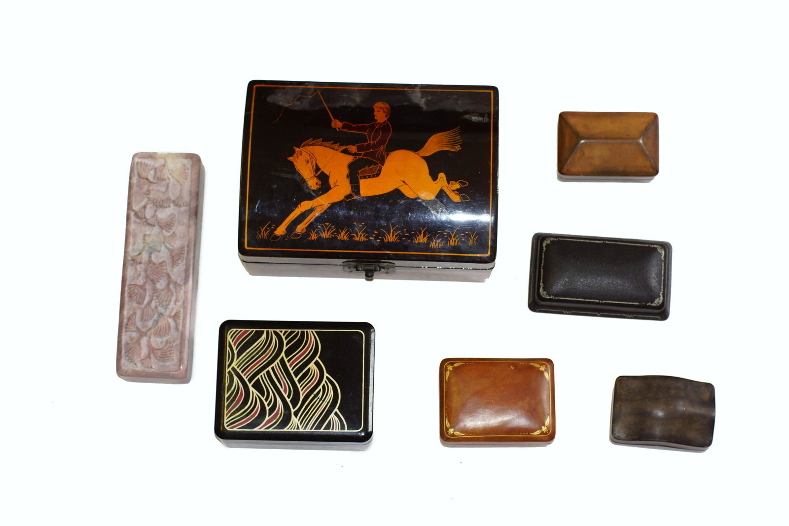 A GROUP OF ASSORTED VINTAGE JEWELRY BOXES: Seven vintage jewelry boxes, one black lacquer wood box with a painting of horseback rider, four boxes decorated with leather, one made from soapstone. Dimensions: Smallest: 1.75 x 2.25 x 3.5 in. Larg