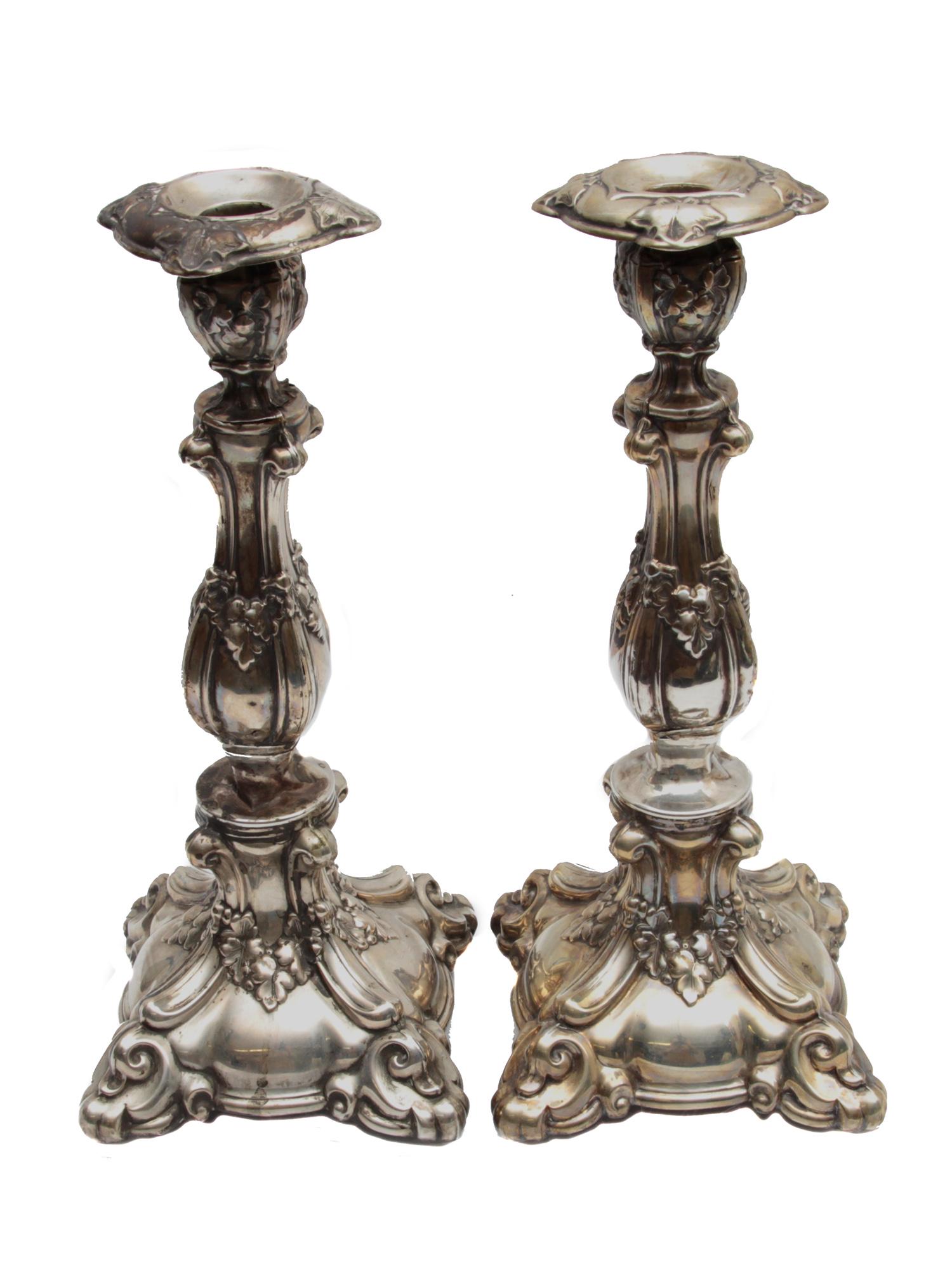 A PAIR OF ANTIQUE RUSSIAN SILVER CANDLE STICKS. 19TH C.: An elegant baroque Judaica Sabbath candlesticks from the late 19th century. Decorative repousse elements with grape leafs and curls. Russian hallmarks on the bottom. Approximate weight 500 gr. Dimensi