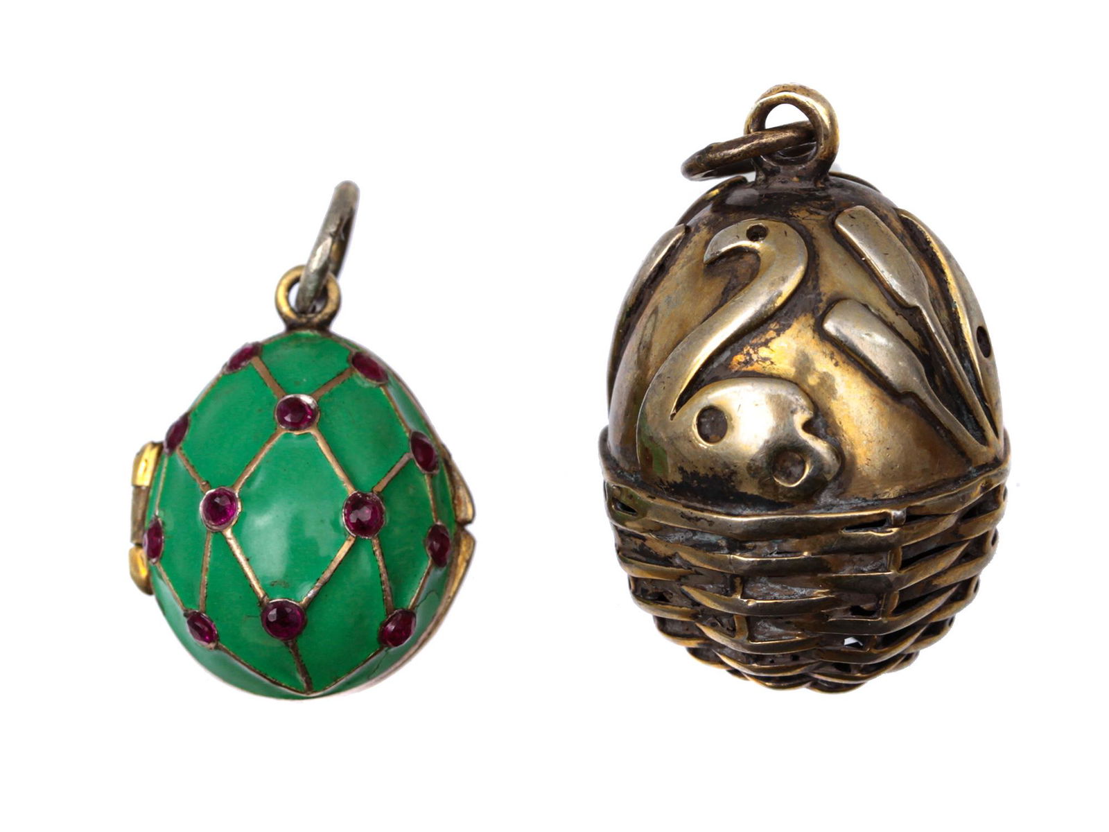 TWO GILT-SILVER AND ENAMEL EGG PENDANTS. 20TH C.: Green enamel locket pendant egg with gilding and inlaid rubies. Inside is hollow, consists of two fastened halves. A silver egg engraved by hand, with images of a swan and reeds. The lower part is dec