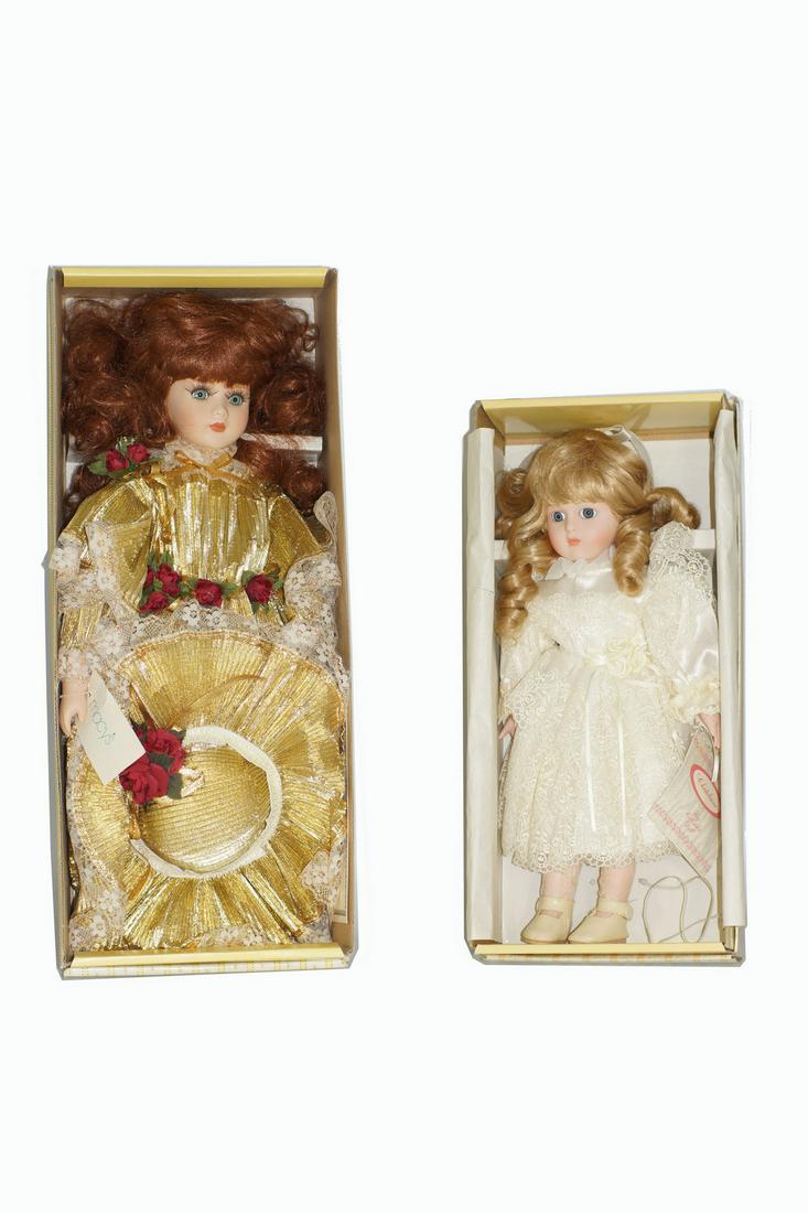 A CONNOISSEUR COLLECTION DOLLS FROM SEYMOUR MANN: A set of two collectible dolls. Features: hand painted porcelain head, arms and legs. Hand finished costumes with lavish detail. Dimensions: Smallest: H 15 in. Largest: H 18 in.