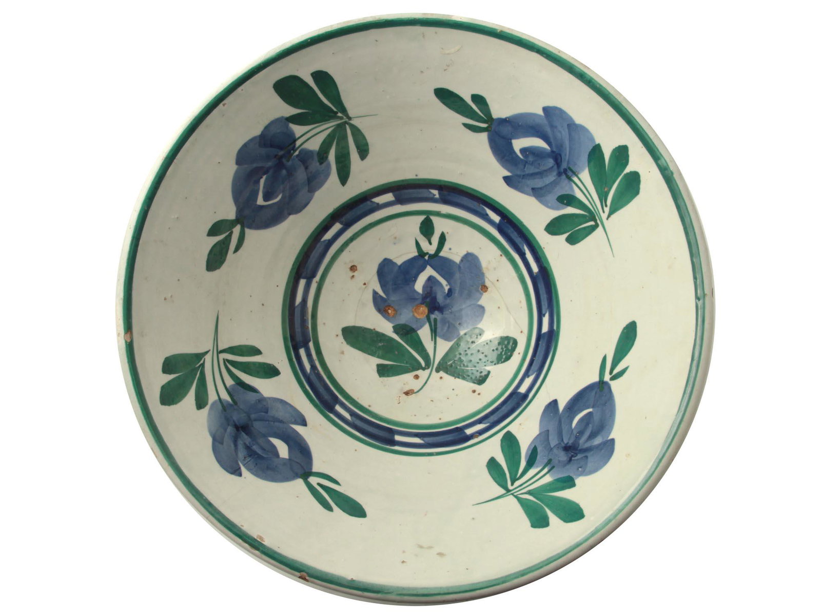 AN ANTIQUE CERAMIC HAND PAINTED BOWL. SPAIN: A deep ceramic bowl covered with white glaze with a blue-green floral ornament inside. With slight scuffs and spots that correspond to age. Circa 19th century. Dimensions: D: 11 1/2 in., (29 cm.)