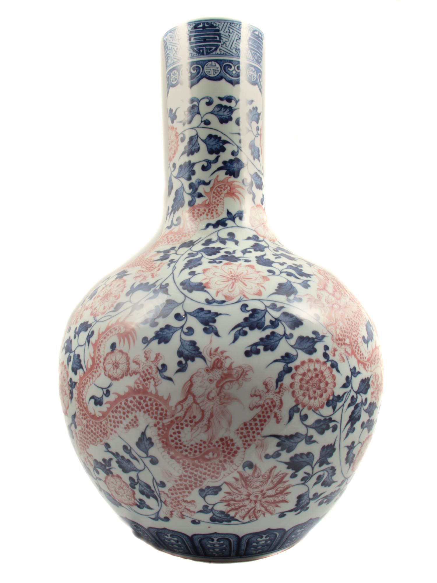 A CHINESE PORCELAIN BOTTLE VASE WITH DRAGONS: A beautiful large porcelain bottle vase with vibrant cobalt blue underglaze stems punctuated with underglaze red flowers and dragons. Marked on the bottom. Circa late 19th century. Dimensions: H: 18 1