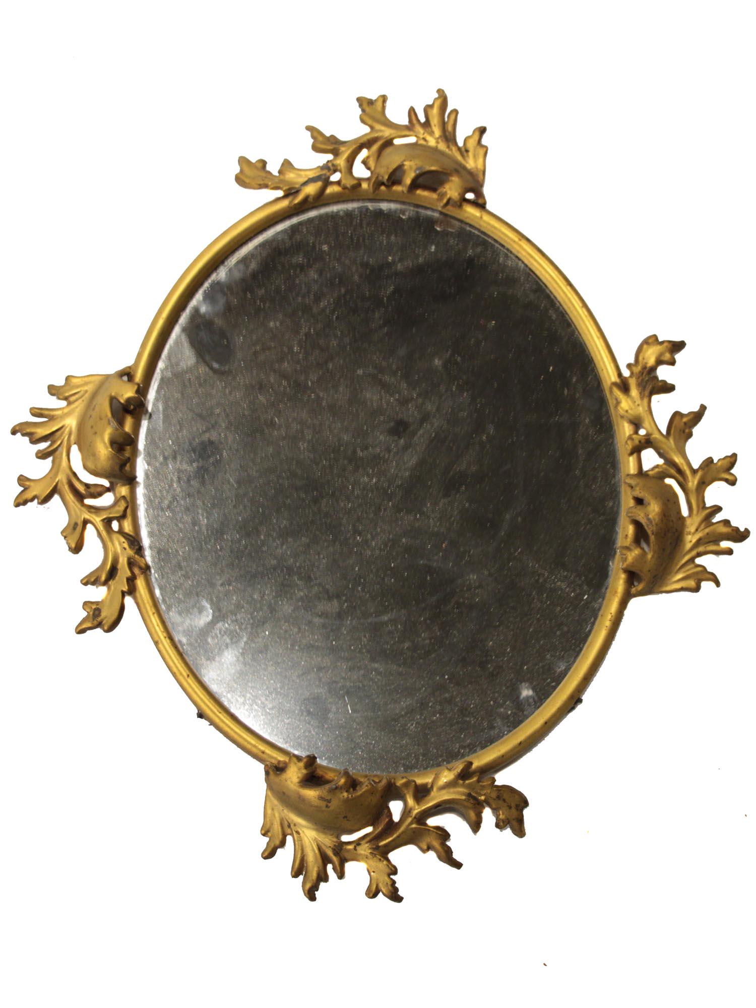 AN ANTIQUE GILT BRASS OVAL MIRROR EARLY 1900's: A lovely wall-hanging oval mirror in a gilded frame. The frame is decorated with graceful leaves. Dimensions: 16 x 14 in., (40 x 35.5 cm.)