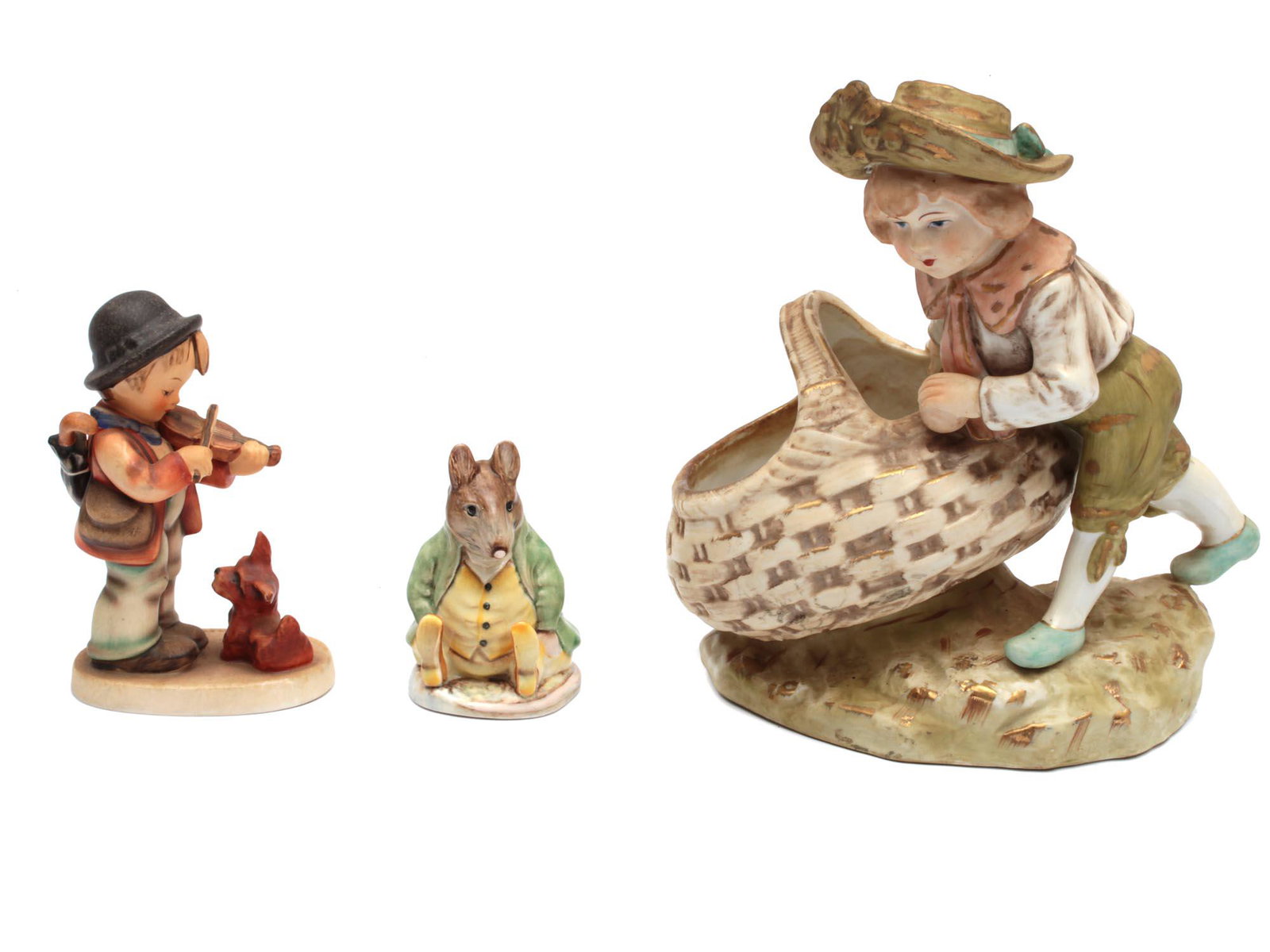 A SET OF THREE VINTAGE PORCELAIN FIGURINES: The set includes:1) A Hummel porcelain figurine depicting a little boy playing the violin and a puppy in front of him. Signed on the base: "M.I. Hummel” and marked with a blue manufacturer's sta
