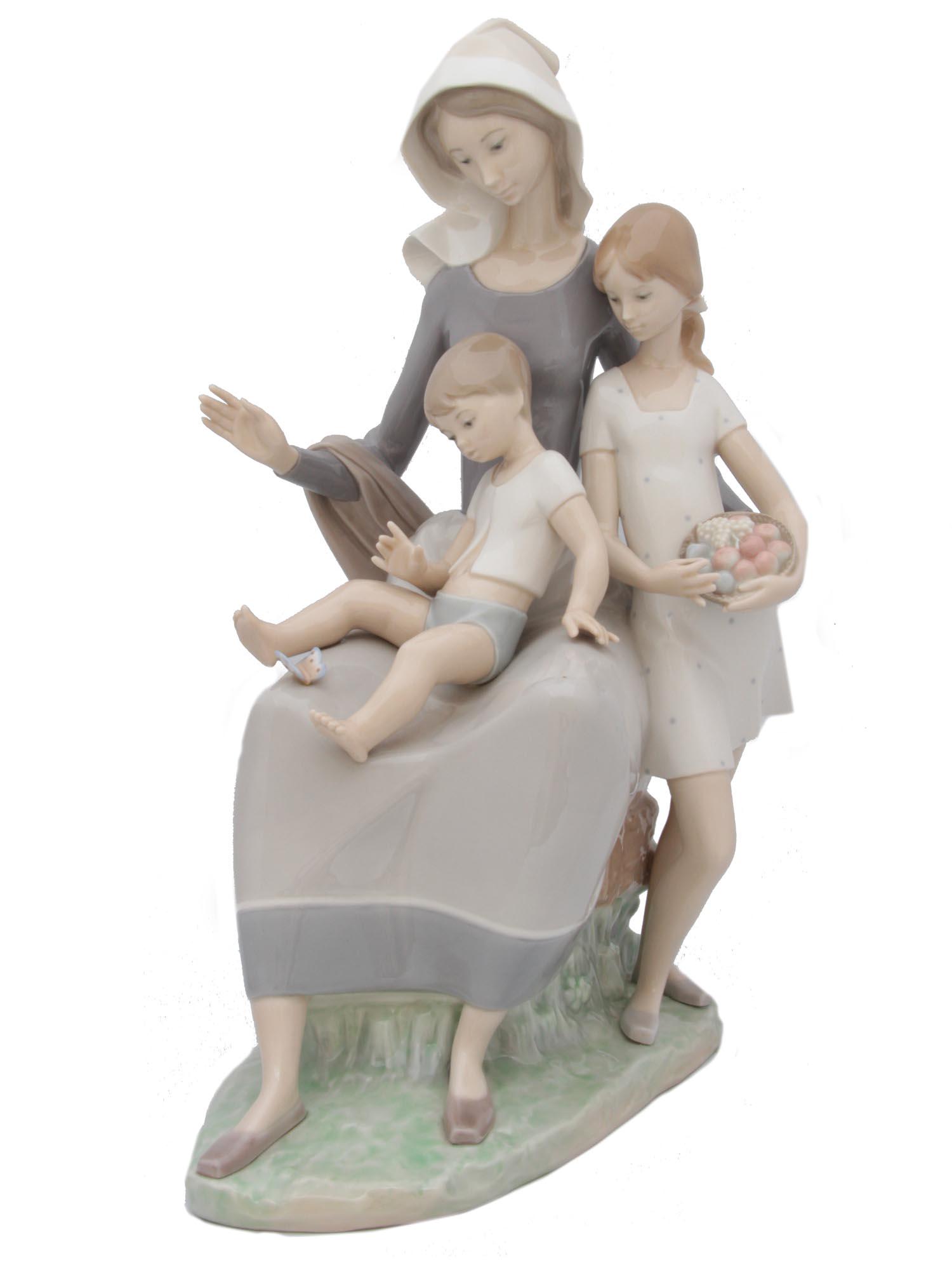 A VINTAGE LLADRO PORCELAIN FIGURINE: A vintage Lladro glazed porcelain figure group depicting a young mother with two children. Stamped on the base "LLADRO /HAND MADE IN SPAIN". Dimensions: H: 15 in.