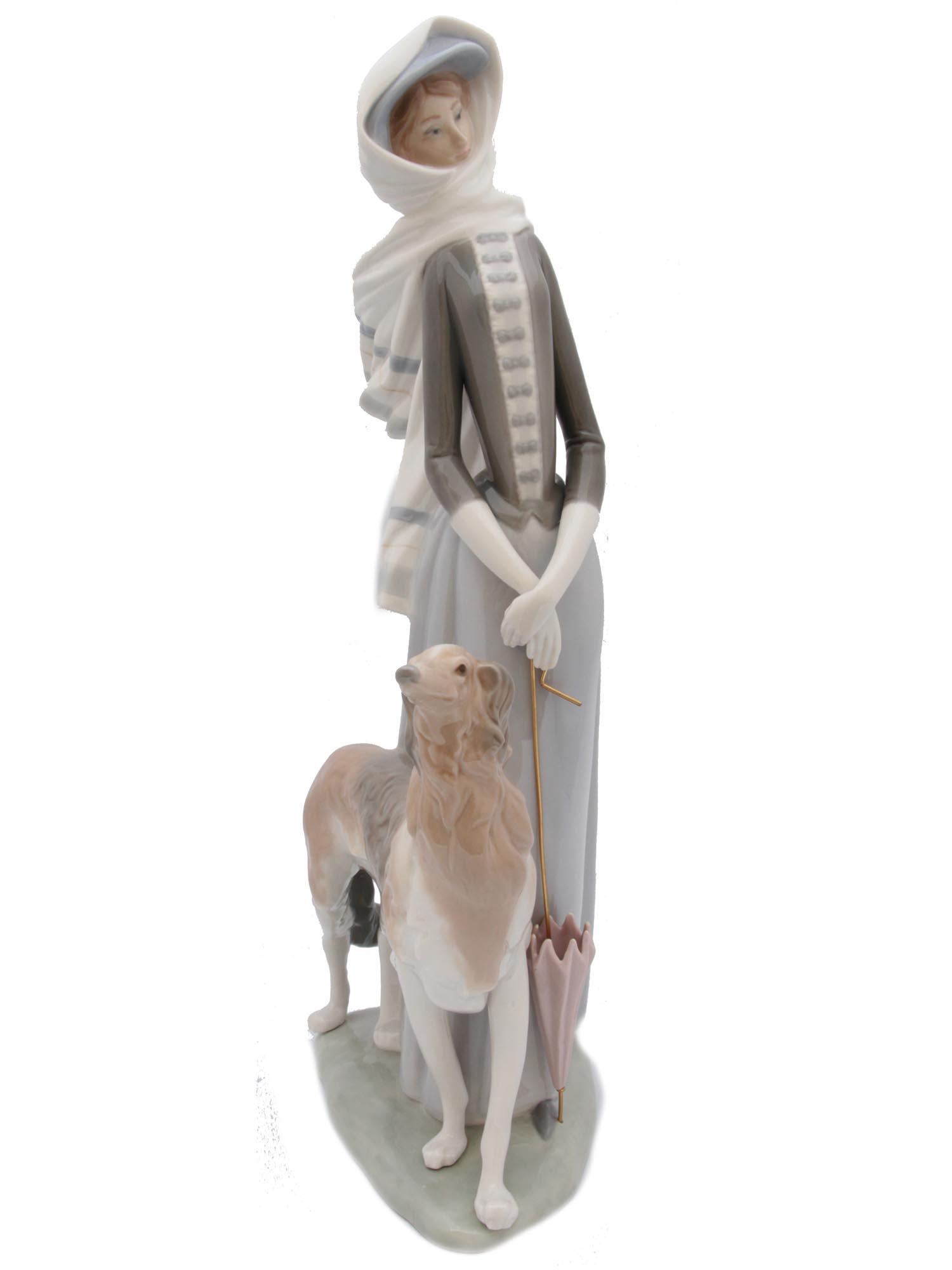 A VINTAGE LLADRO PORCELAIN FIGURINE: A vintage Lladro glazed porcelain figurine depicting a graceful young lady walking with greyhound. Stamped on the base "LLADRO /HAND MADE IN SPAIN". Dimensions: 16 x 7 1/2 in.
